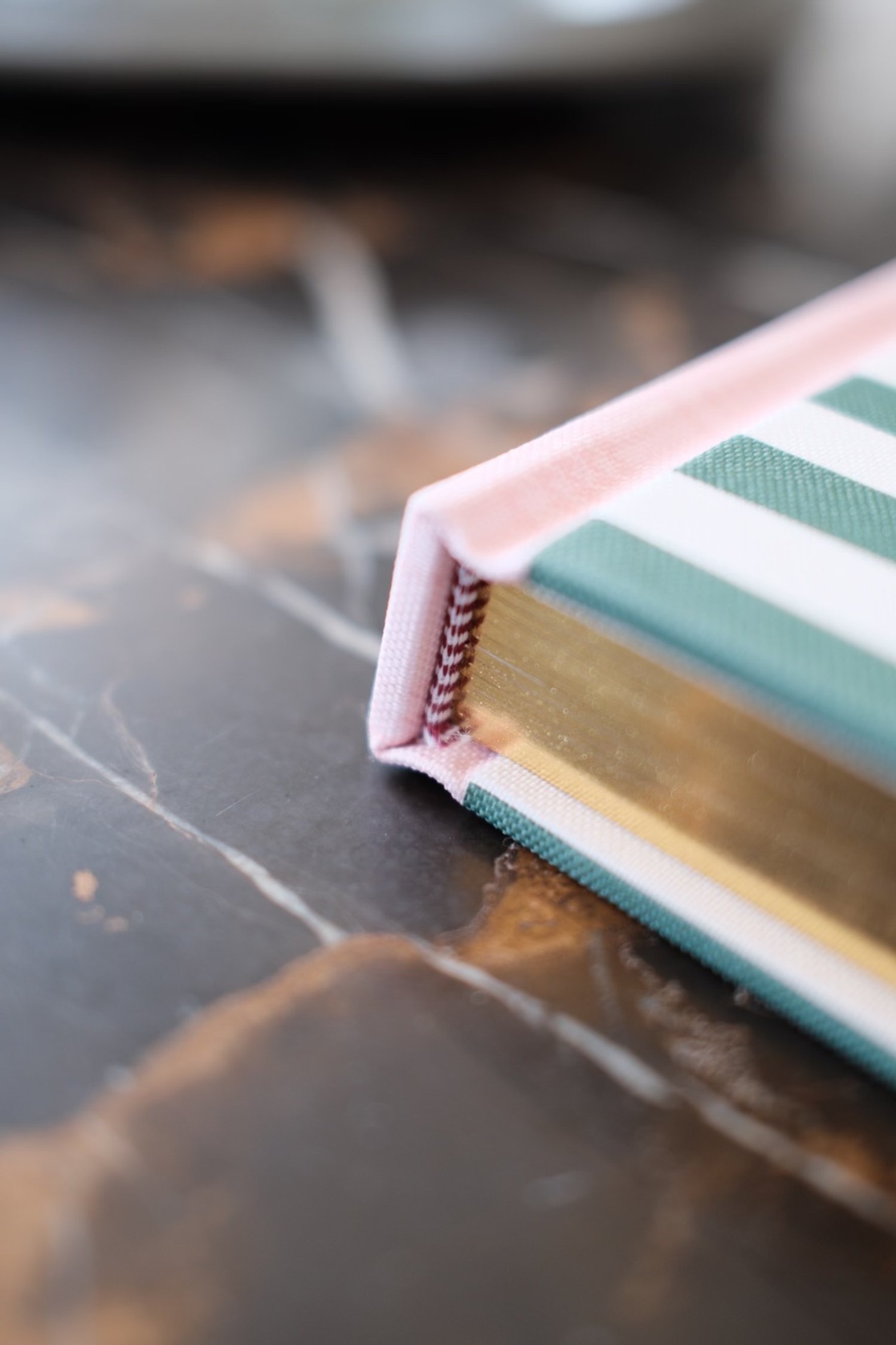 Detailed view of checkered book band and gold foil pages on Nooks, Crannies, Cocktails and Other Musings