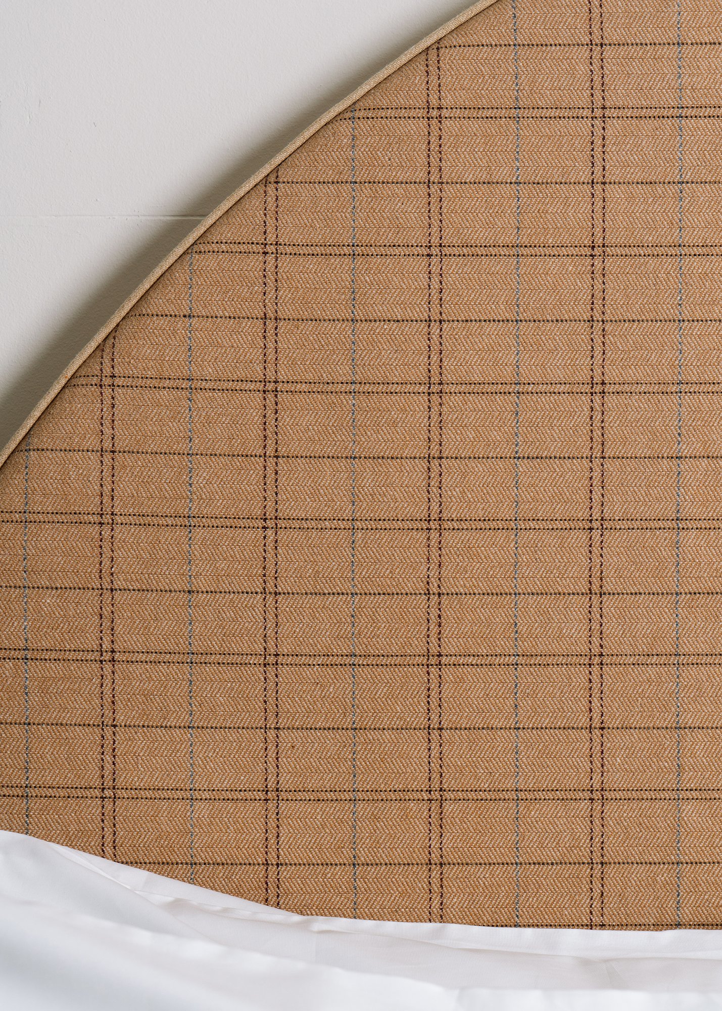 Detail of demilune headboard of Château Bed showing the plaid fabric up close
