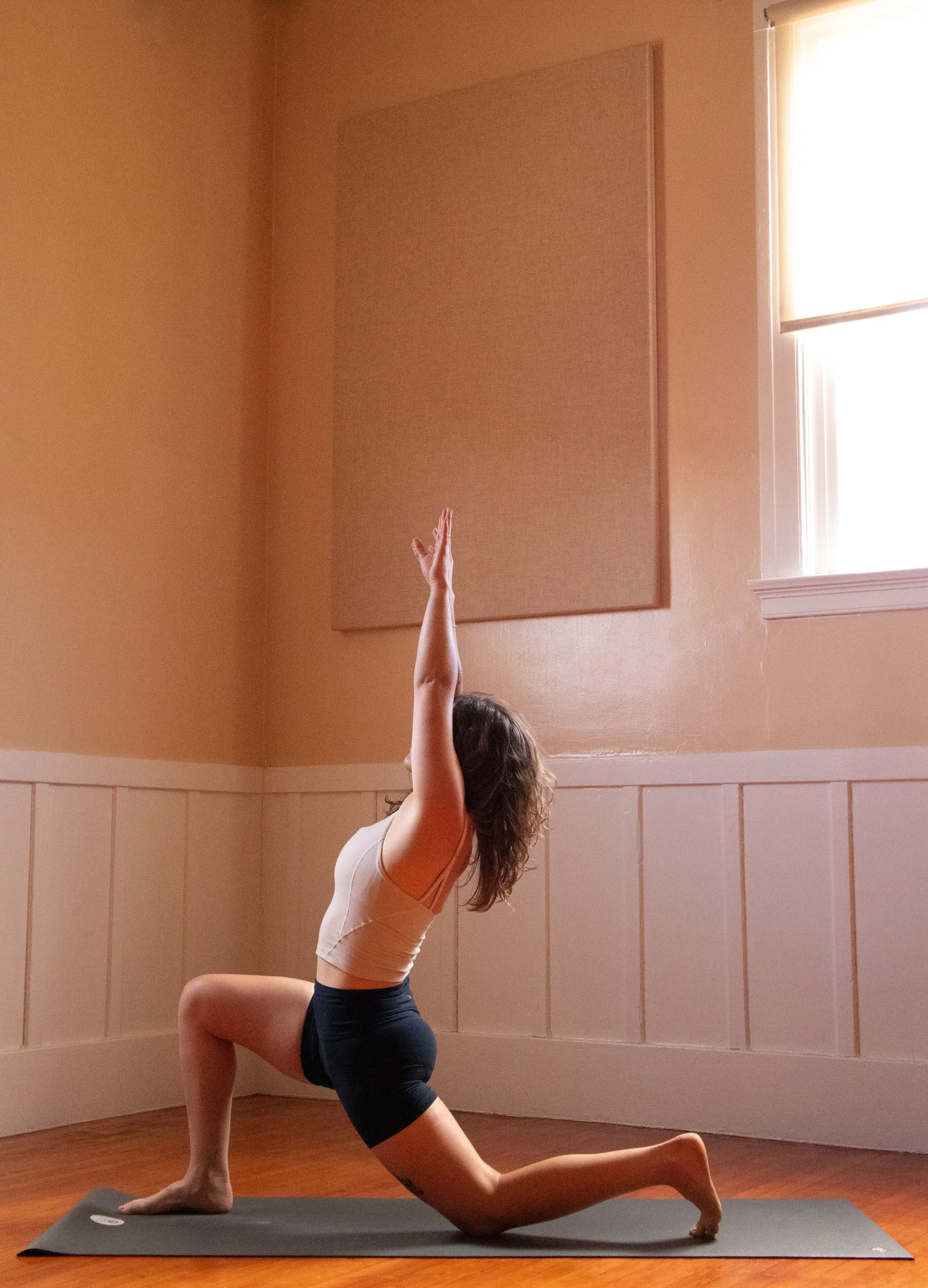 Haley Havelock in a high lunge, arms reaching overhead, at The Castro Room in San Francisco