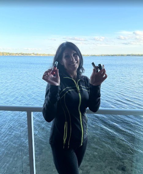Woman holding Vallee Naturals holistic skincare products by the lake in Michigan
