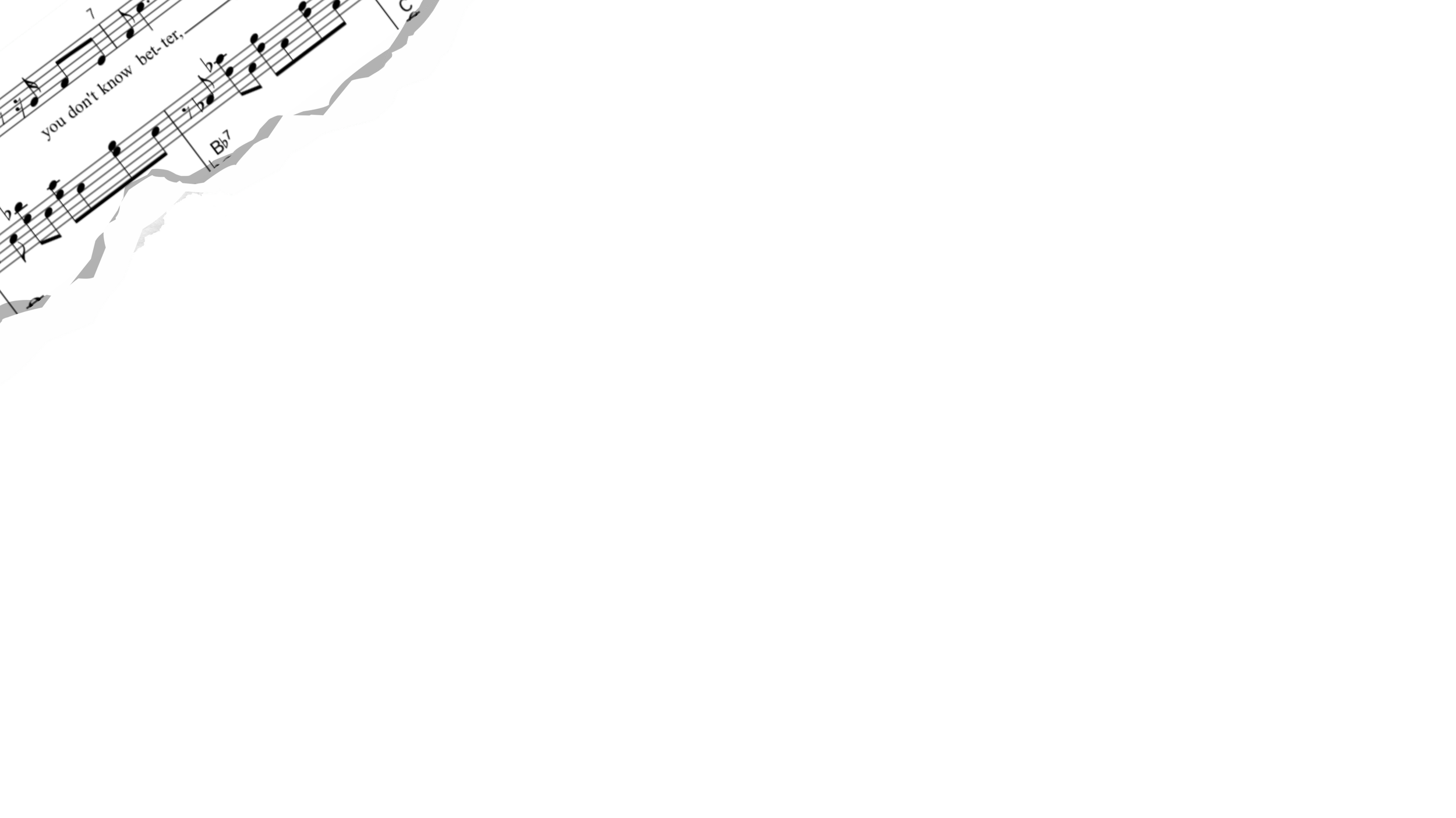 Sheet music torn and scattered on a black surface, with visible musical notes and lyrics.