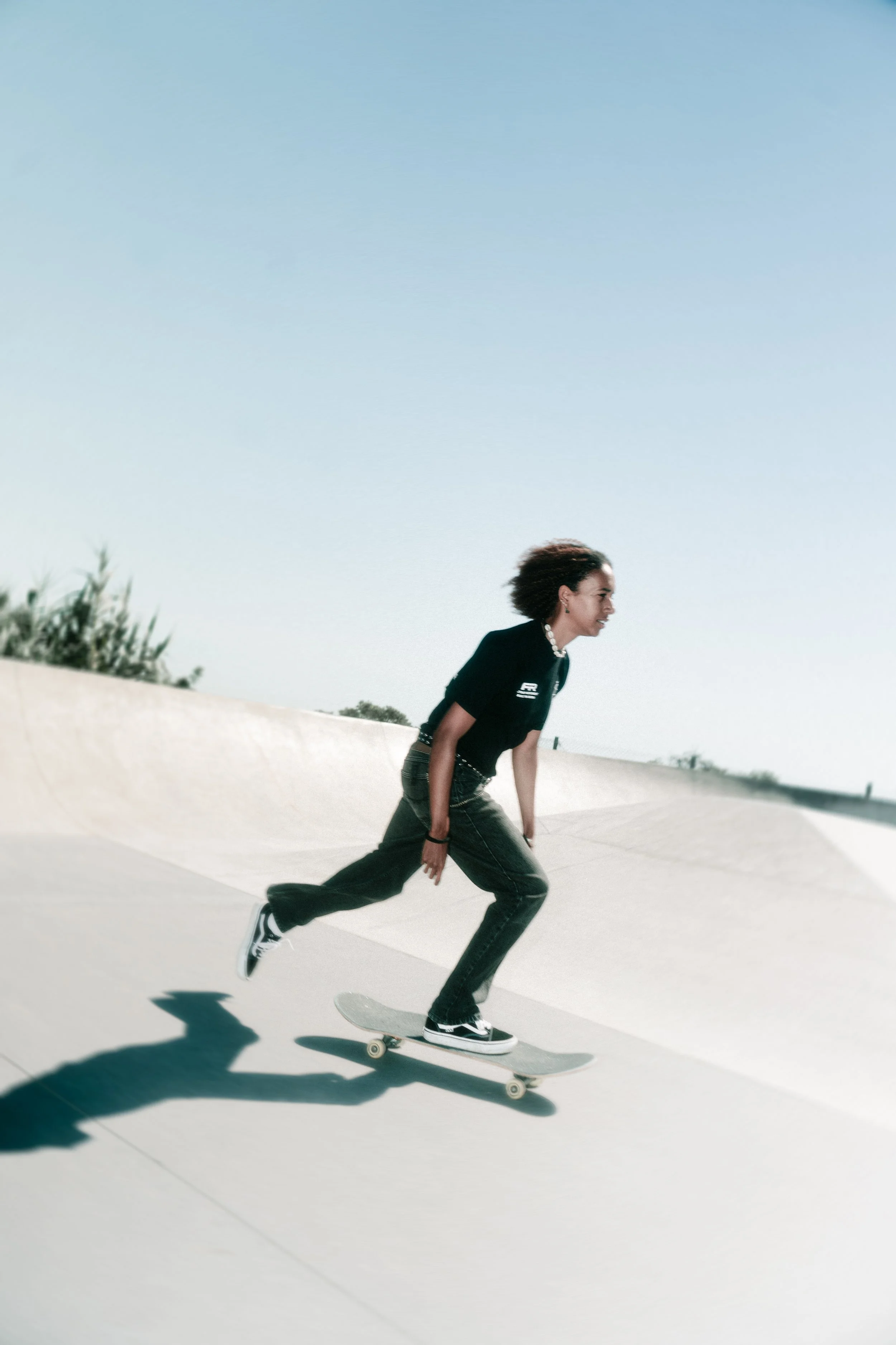 Joven mujer en una skate en una pista en un día soleado.