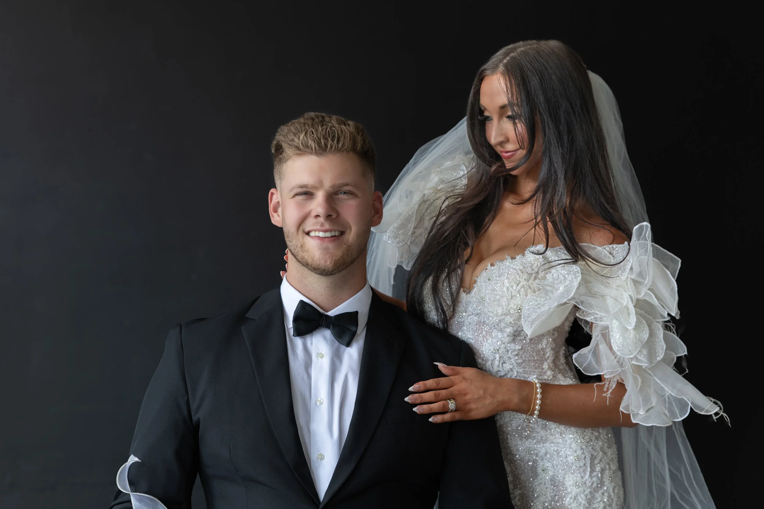 Bride admiring group in studio portrait. 