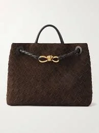 Brown handbag with a handle and decorative gold bow detail