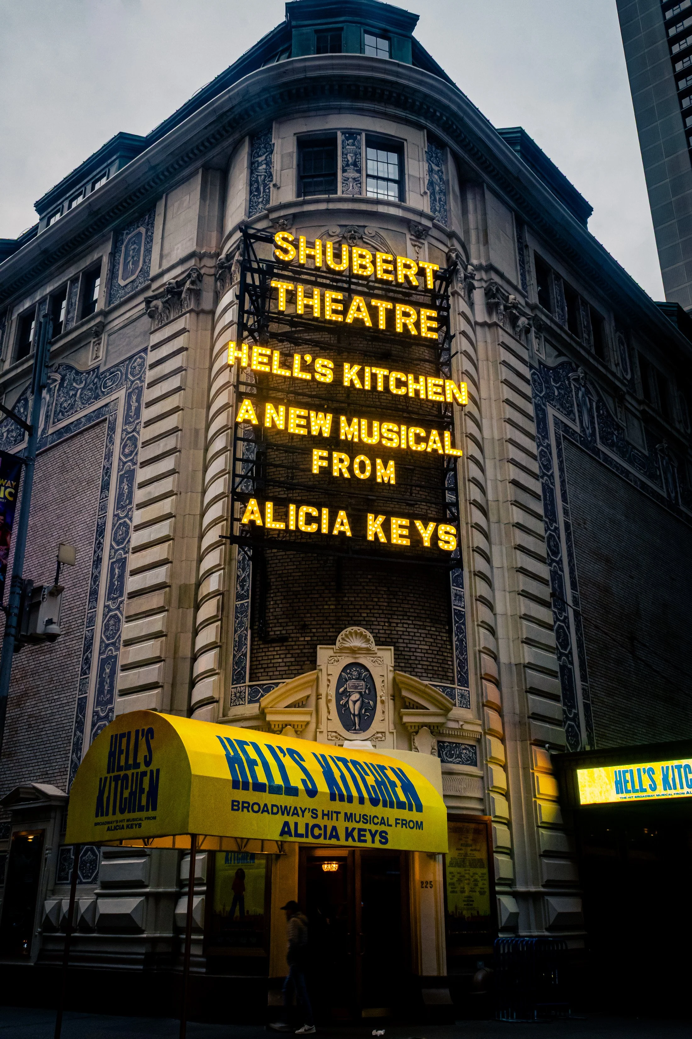 © 2025 Pablo Esteban (A Stage Above the Street. The warm marquee lights cut through the evening)