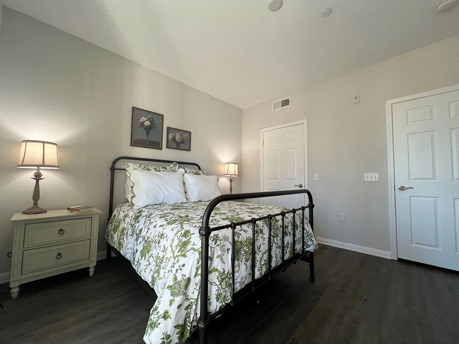  Primary Bedroom in Raincross Apartment Home with plank flooring, private balcony access, and spacious closet. 