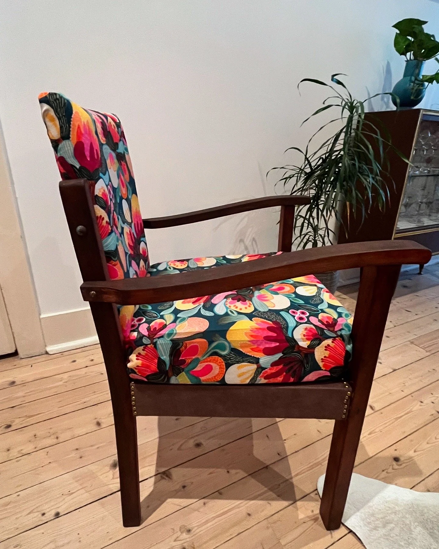 Wooden armchair with colorful floral upholstery
