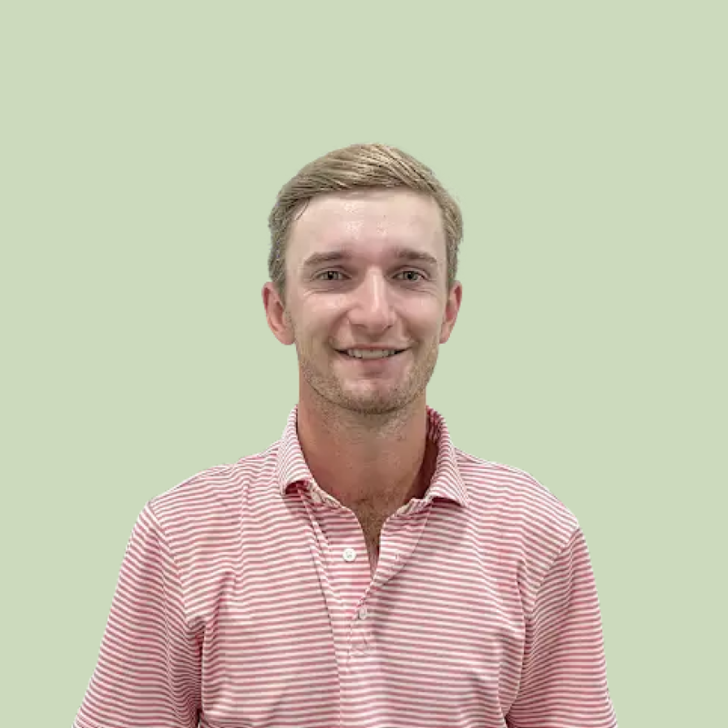 Close-up of a young man with blonde hair, smiling, wearing a red and white striped shirt against a pale green background.