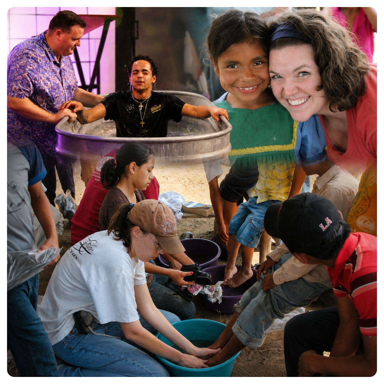 People washing children's feet in buckets during a community event.