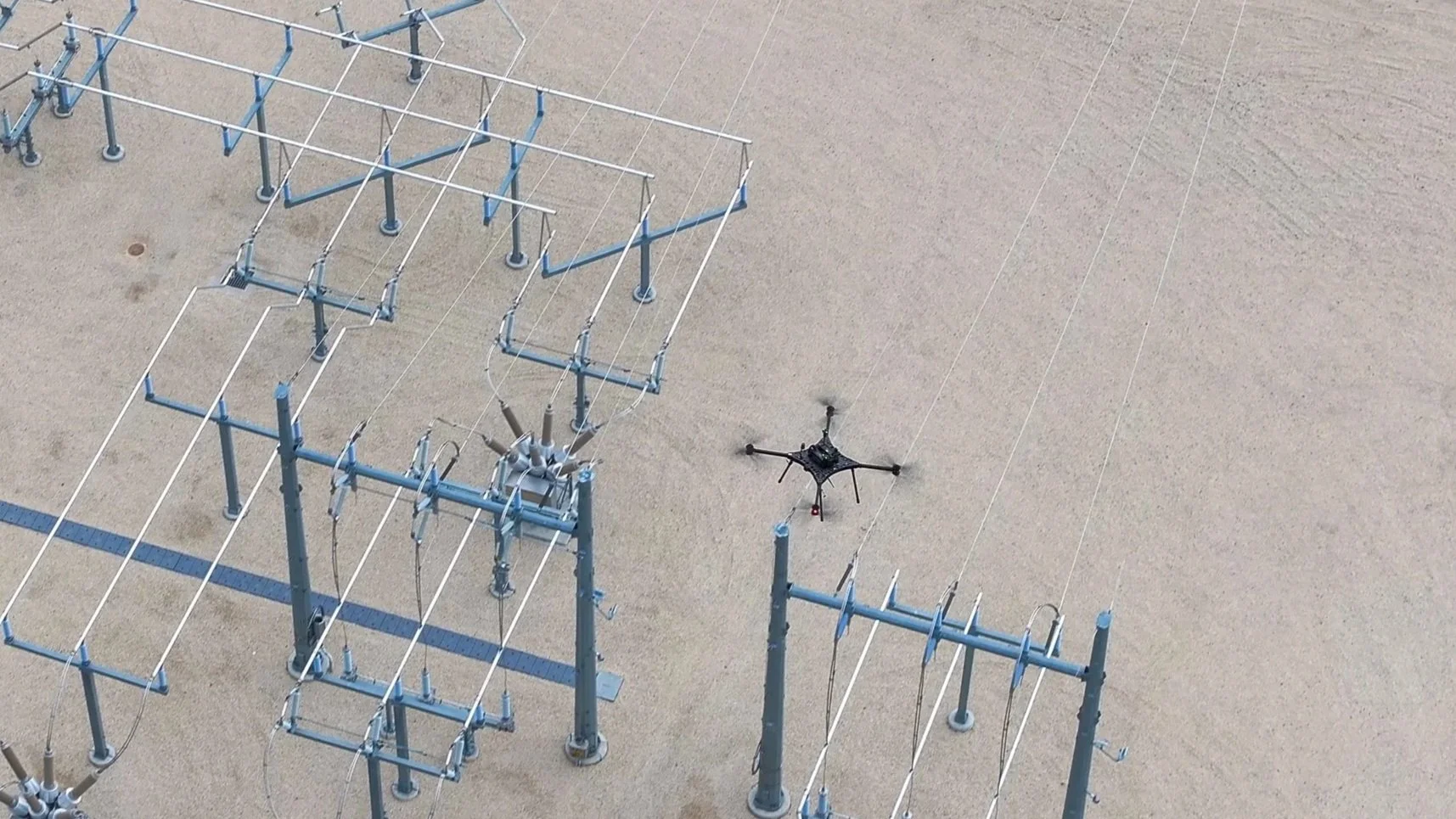 Aerial LiDAR data collection above a transmission line load station for infrastructure mapping and analysis.
