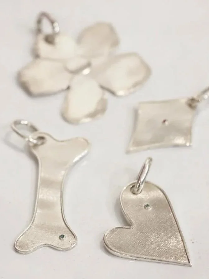 Close-up of a curly-haired dog wearing a brown and white bandana with a flower-shaped tag on its collar.