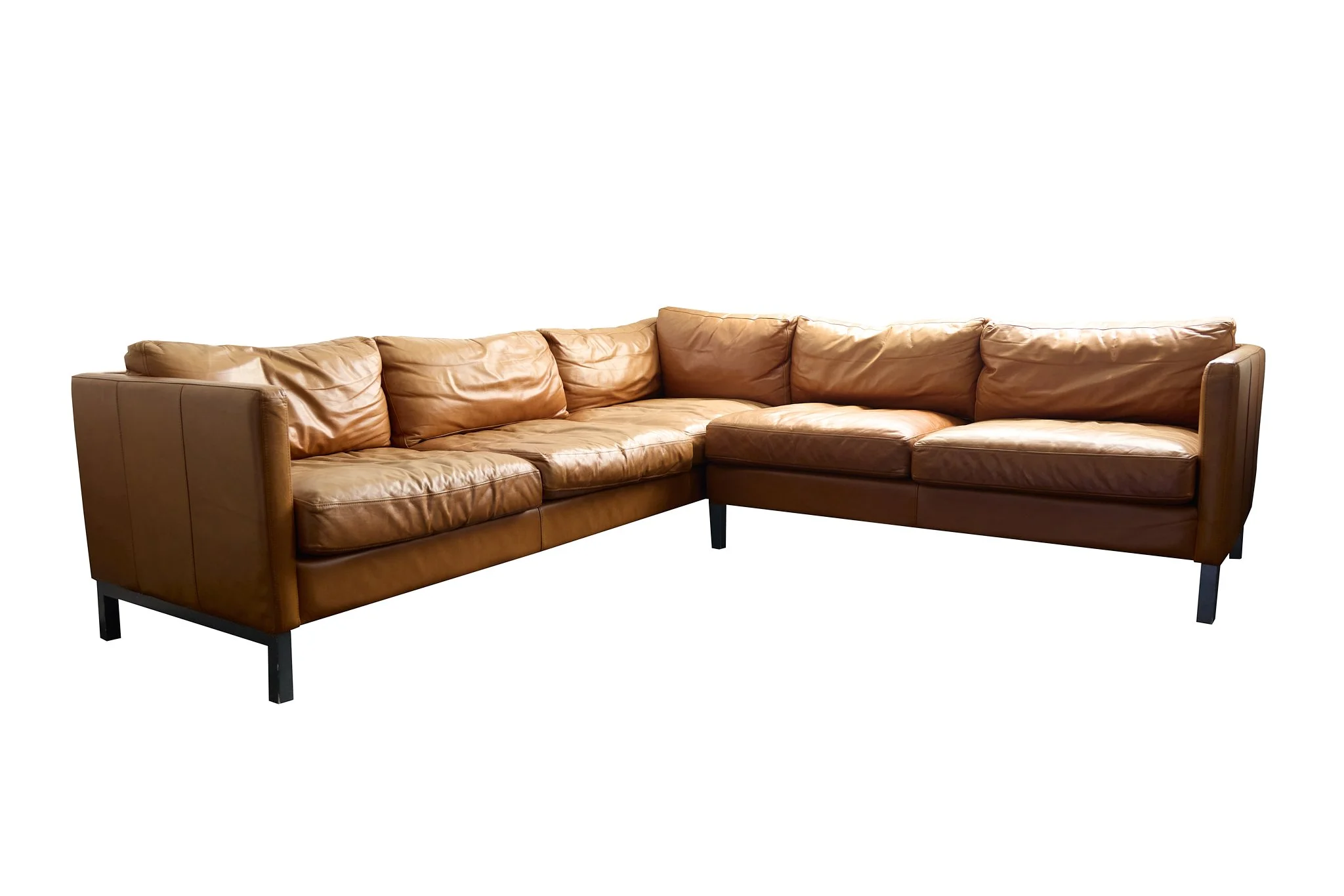Brown leather sectional sofa against white background.