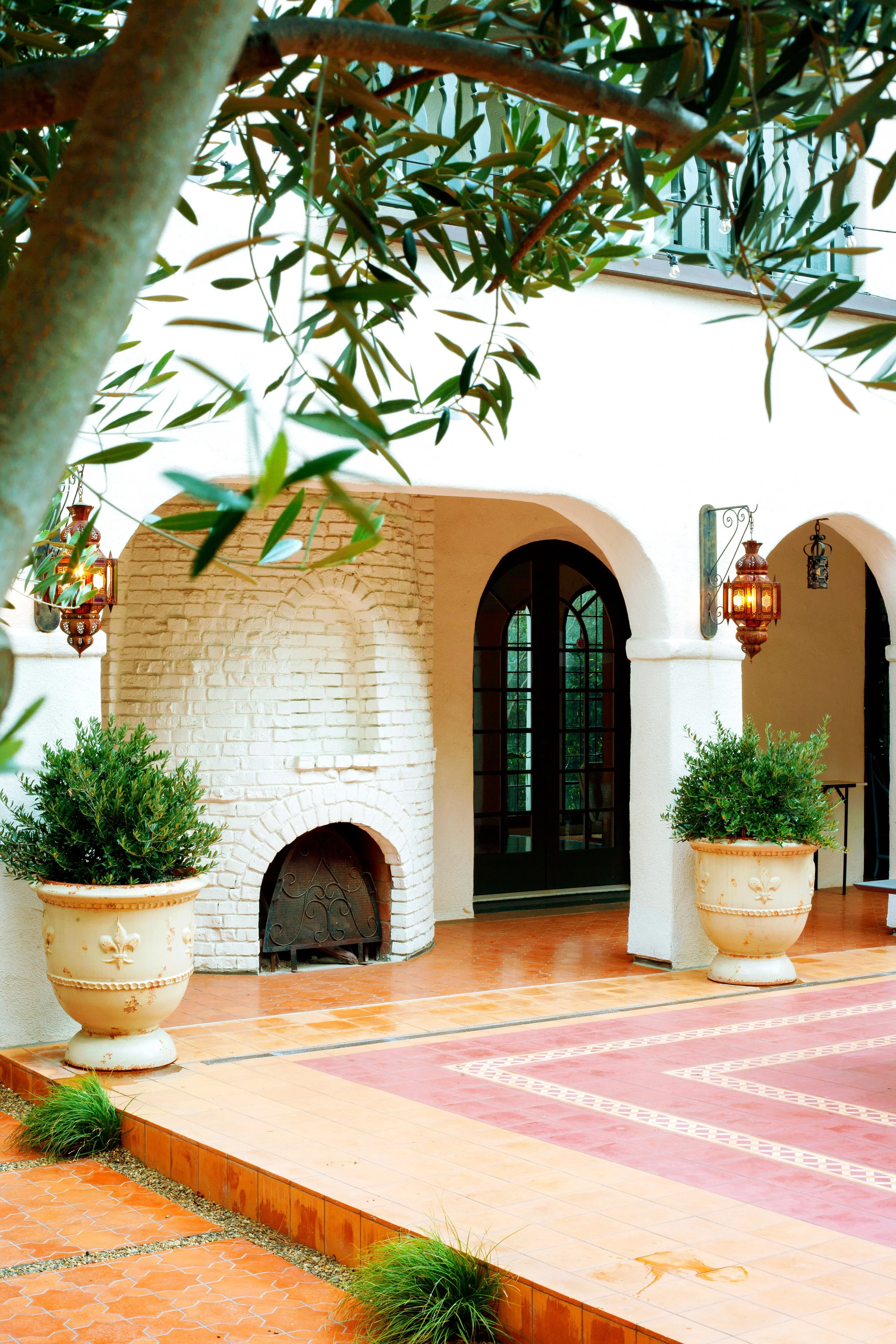 Restored Spanish estate in Hollywood Hills with new vs old terracotta tiles, layers of lush landscaping, lawn space, fire pit lounge, dining and pool.