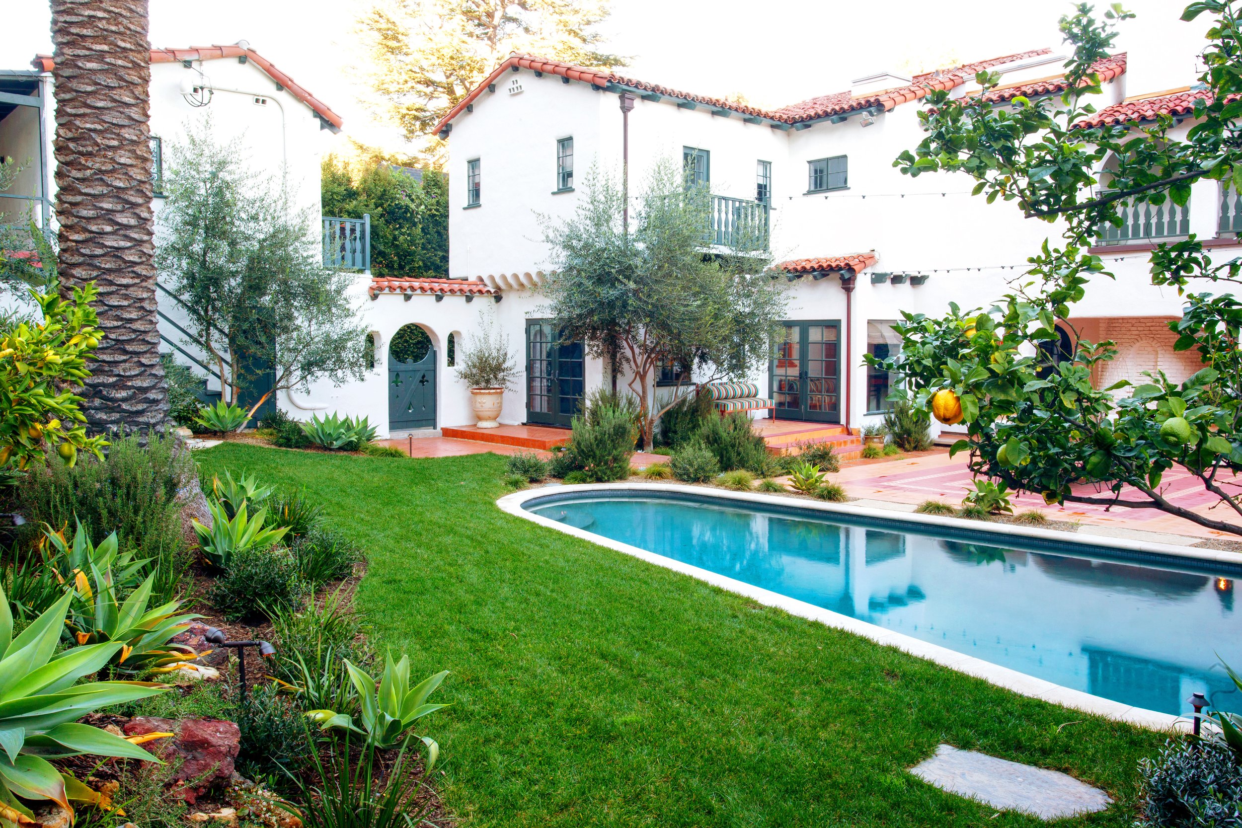 Restored Spanish estate in Hollywood Hills with new vs old terracotta tiles, layers of lush landscaping, lawn space, fire pit lounge, dining and pool.