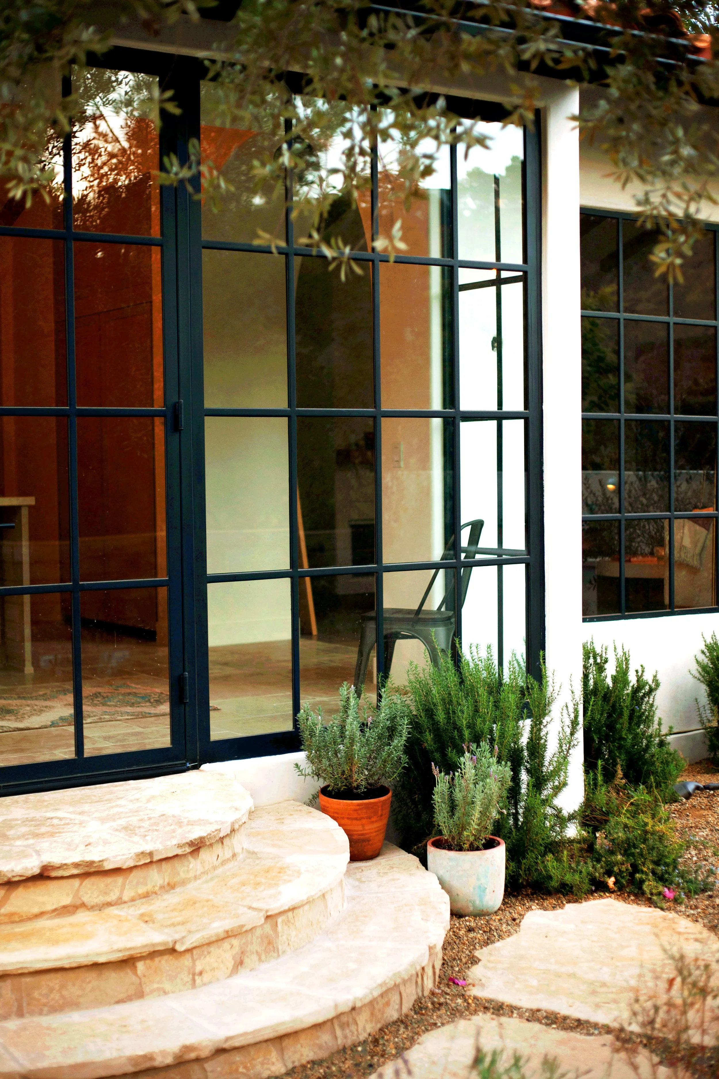 Mountain top rustic property with clean naturalistic feel, reclaimed wood fencing, Spanish elements, layered Mediterranean plantings, Mexican pebbles, and multiple lounge / dining layouts.