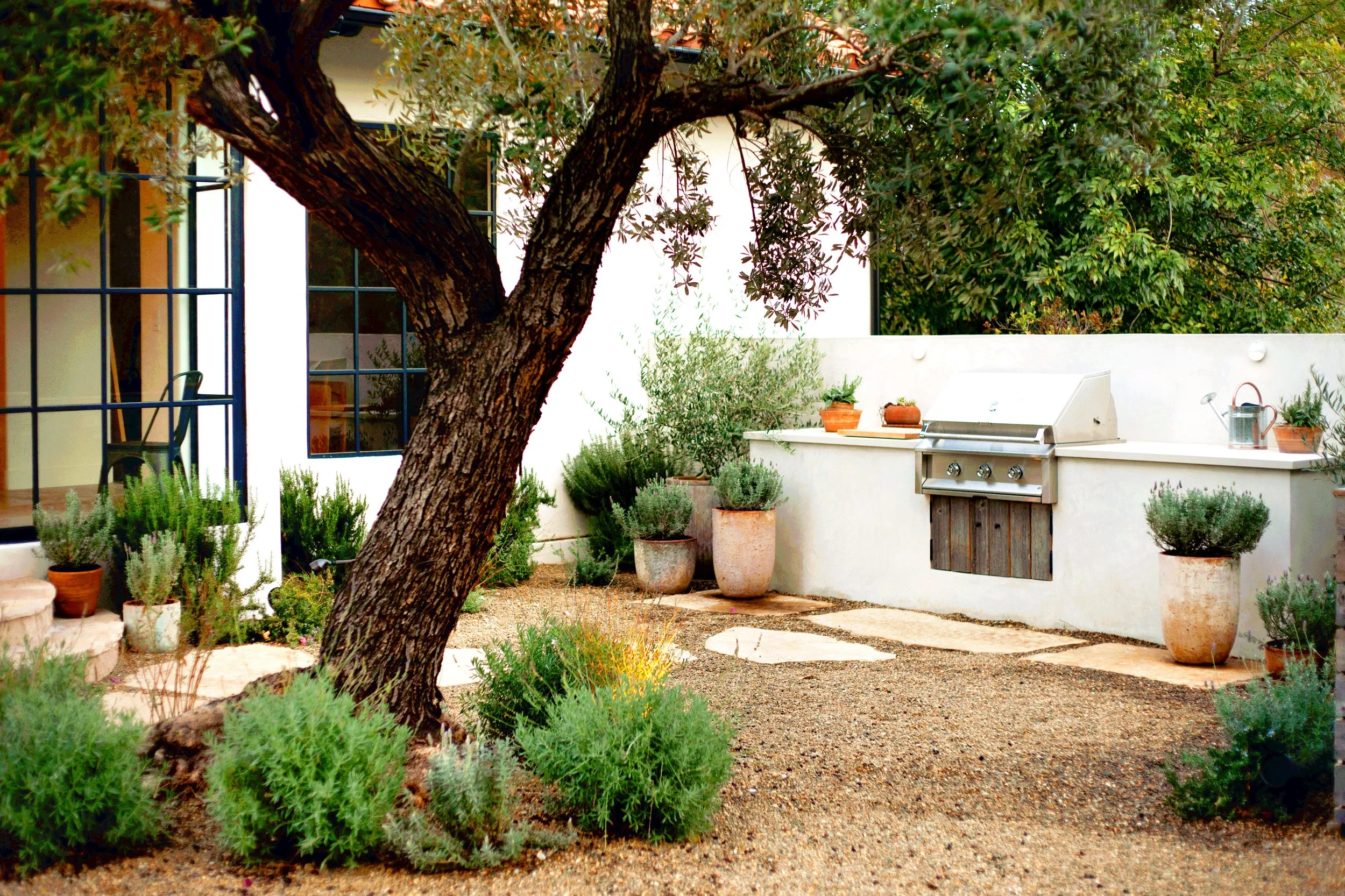 Mountain top rustic property with clean naturalistic feel, reclaimed wood fencing, Spanish elements, layered Mediterranean plantings, Mexican pebbles, and multiple lounge / dining layouts.