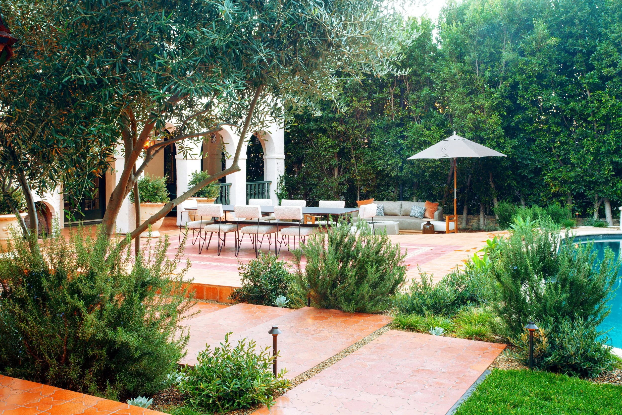 Restored Spanish estate in Hollywood Hills with new vs old terracotta tiles, layers of lush landscaping, lawn space, fire pit lounge, dining and pool.