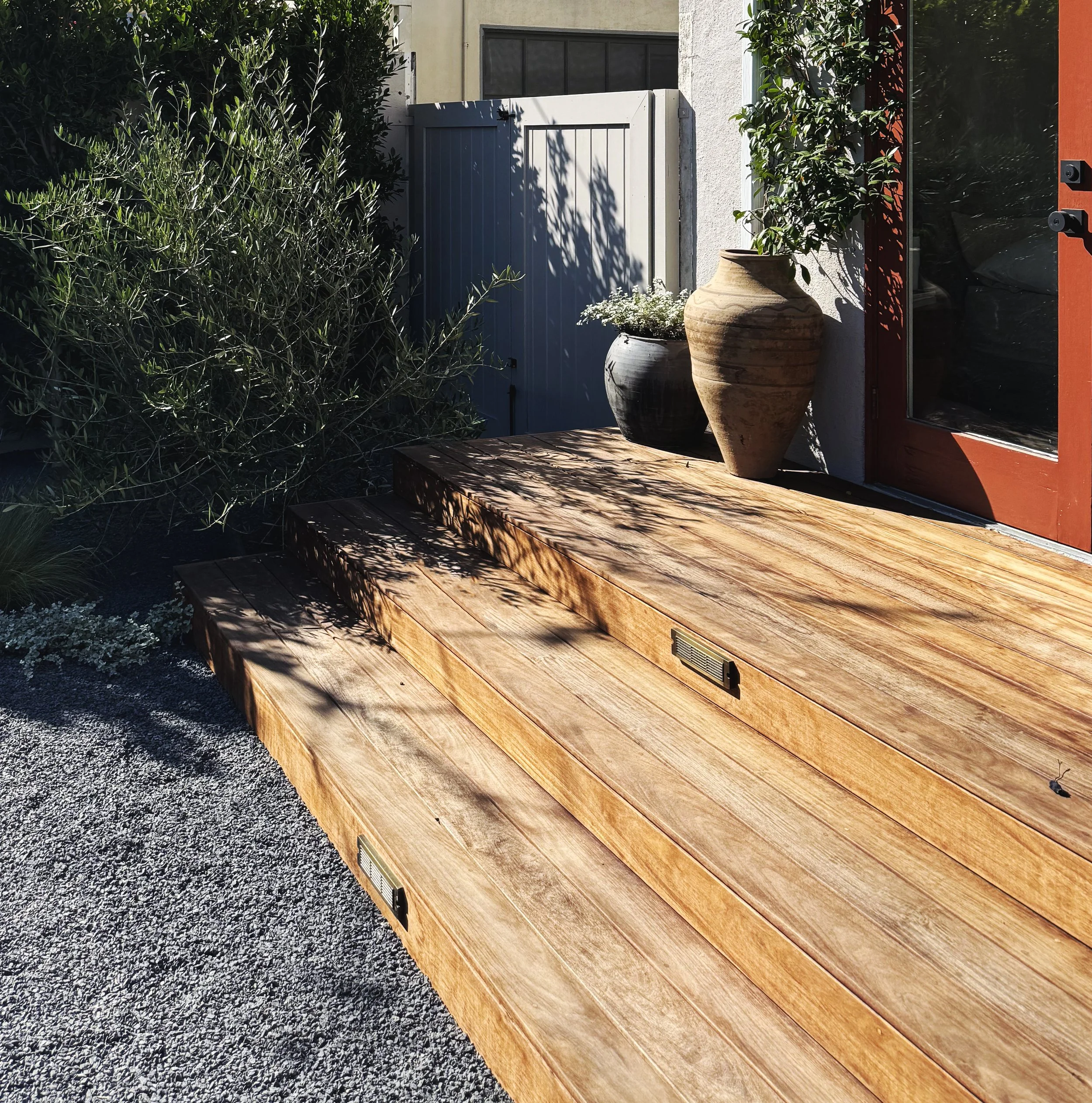 In-ground linear ipe wood deck with metal & wood shade structure, dining table & chairs