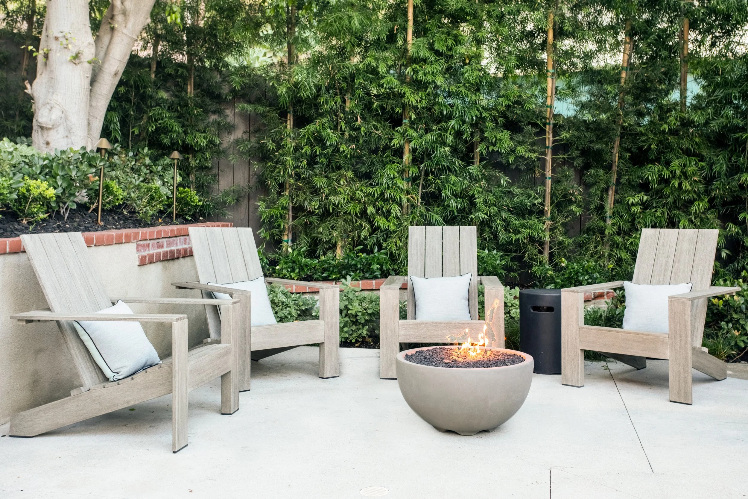 Poolside lounges, fire pit with adirondack chairs, brick courtyard with additional fire pit lounge, lush plantings with a clean natural aesthetic.
