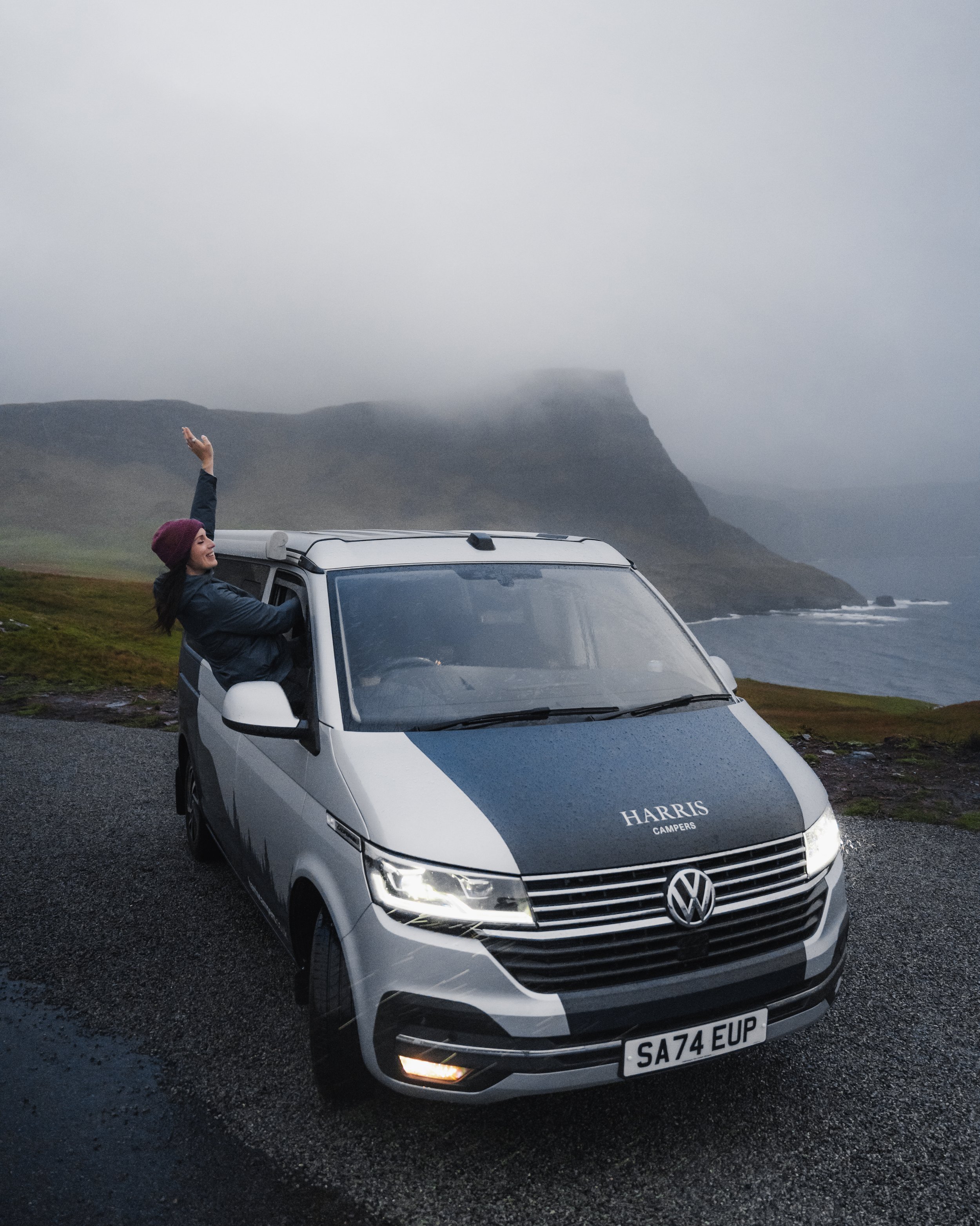 The Best Campervan hire Scotland, Campervan hire Glasgow, Harris Campers camper van parked on the Isle of Skye, Neist Point. Girl having fun living the van life in Scotland. Campervan hire Scotland