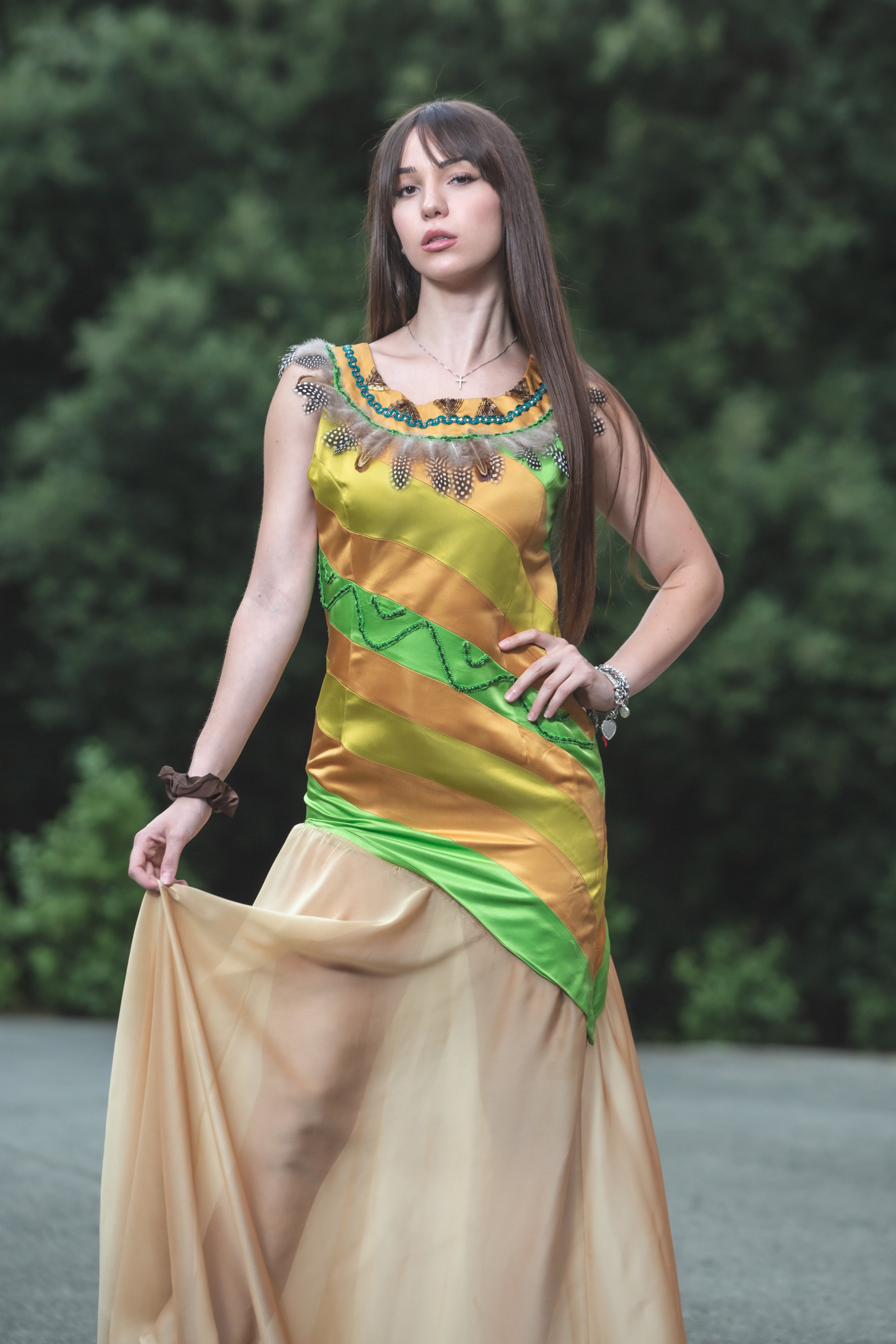 abito realizzato con strisce realizzate a mano in diversi colori di duchesse cuciti insieme che vanno dal sabbia, verde acido e verde erba. Lo scolloè molto particolare, decorato e ricamato a mano con perline dorate e bronzo, passamanerie verdi e piu