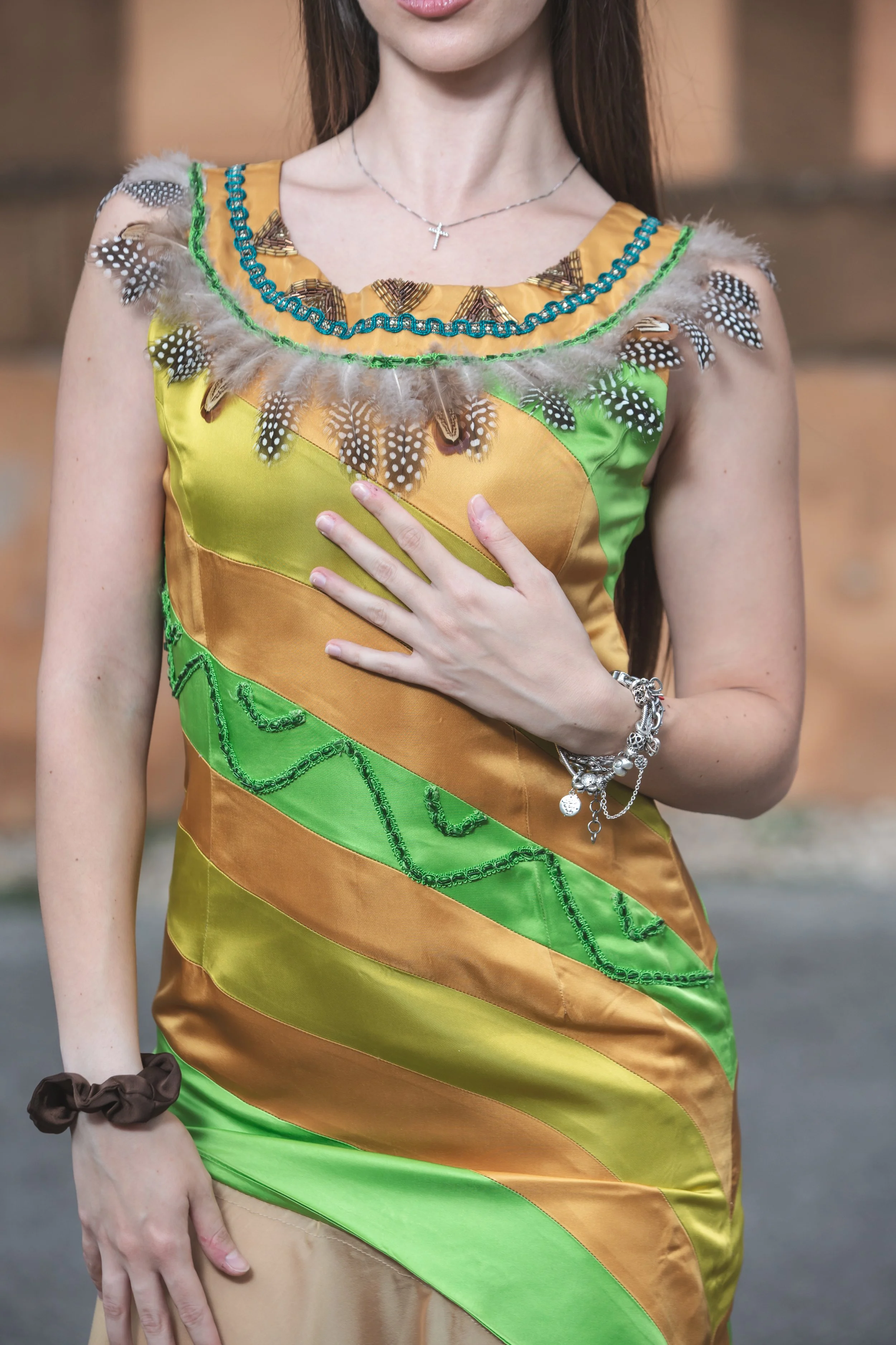 abito realizzato con strisce realizzate a mano in diversi colori di duchesse cuciti insieme che vanno dal sabbia, verde acido e verde erba. Lo scolloè molto particolare, decorato e ricamato a mano con perline dorate e bronzo, passamanerie verdi e piu