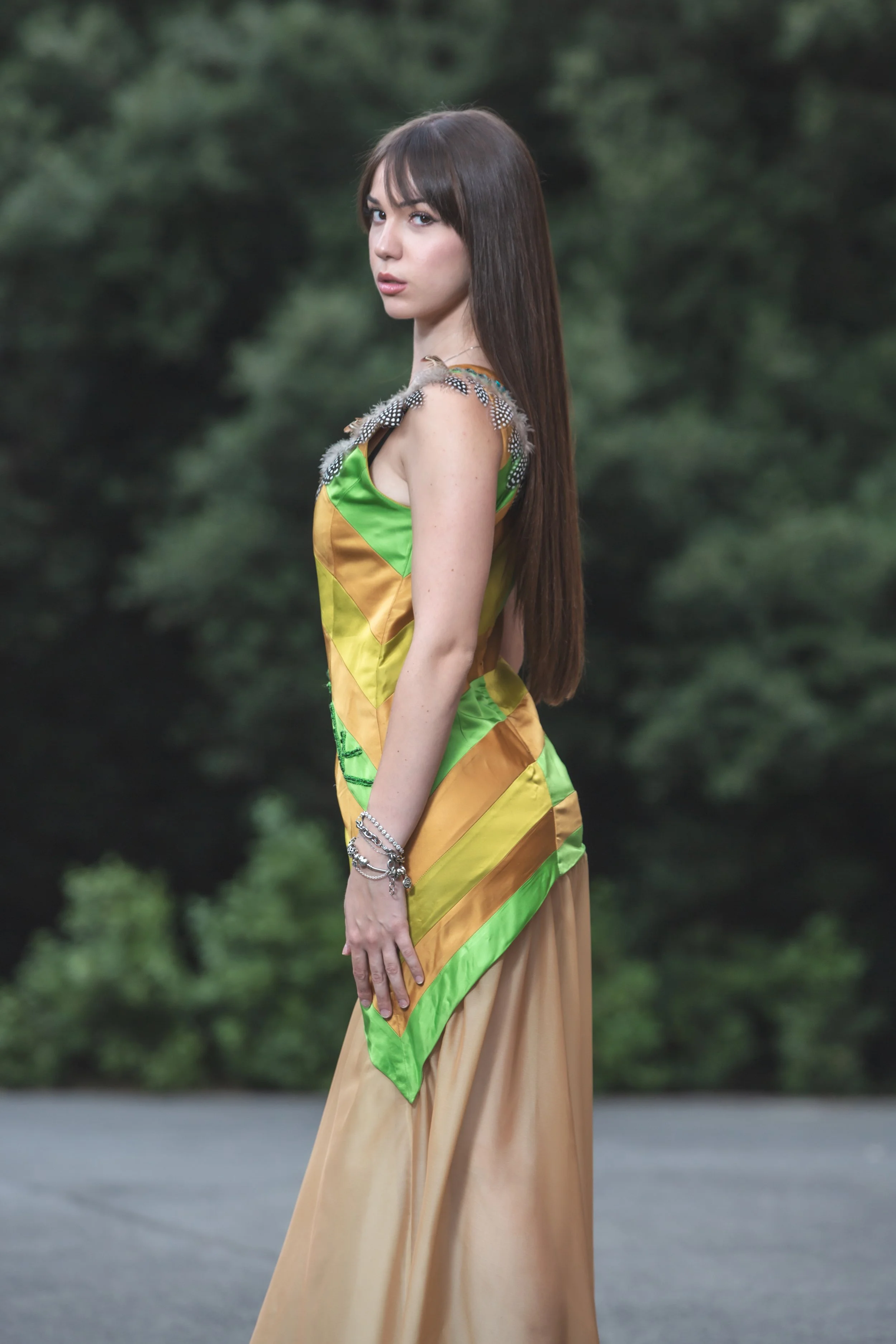 abito realizzato con strisce realizzate a mano in diversi colori di duchesse cuciti insieme che vanno dal sabbia, verde acido e verde erba. Lo scolloè molto particolare, decorato e ricamato a mano con perline dorate e bronzo, passamanerie verdi e piu