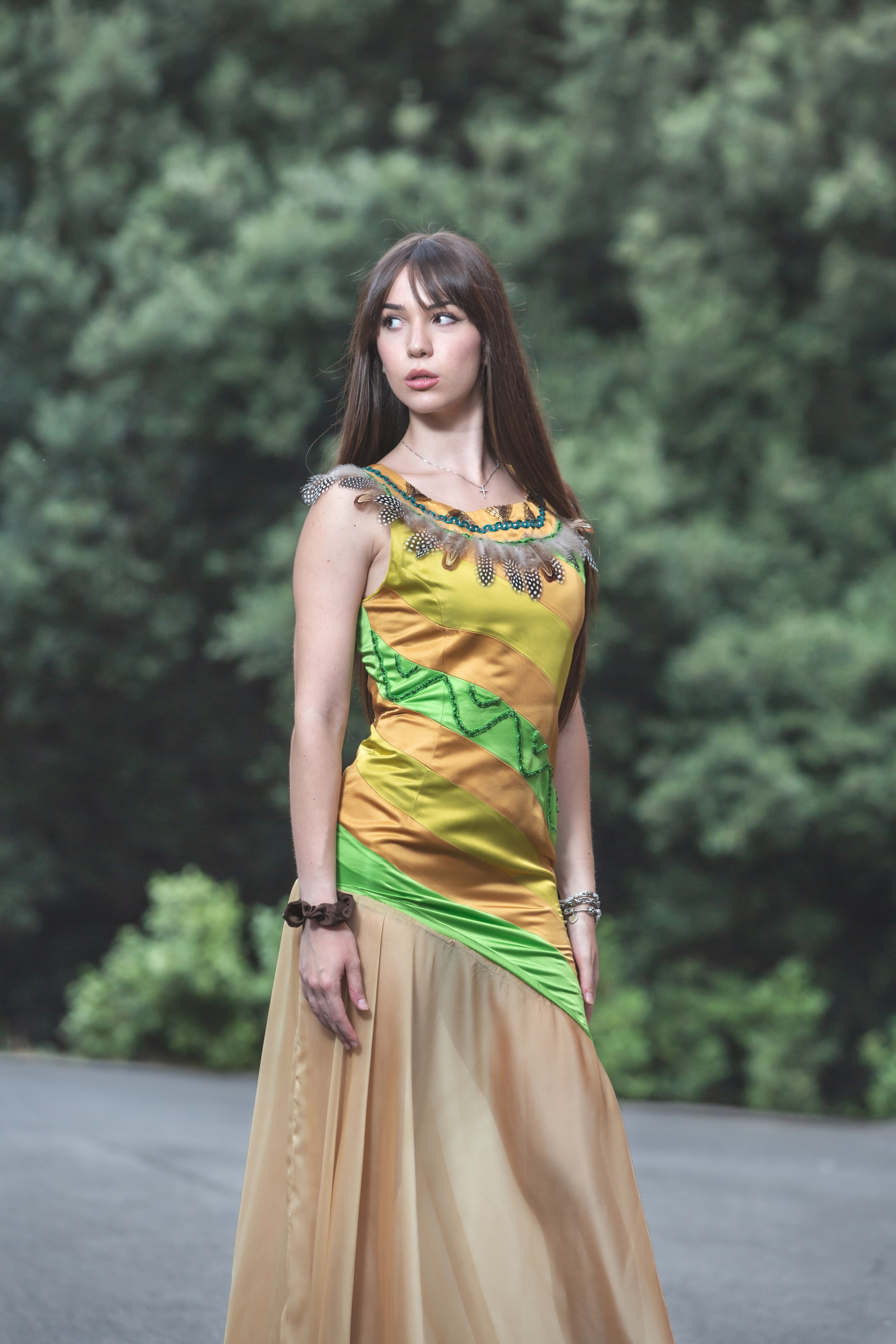 abito realizzato con strisce realizzate a mano in diversi colori di duchesse cuciti insieme che vanno dal sabbia, verde acido e verde erba. Lo scolloè molto particolare, decorato e ricamato a mano con perline dorate e bronzo, passamanerie verdi e piu