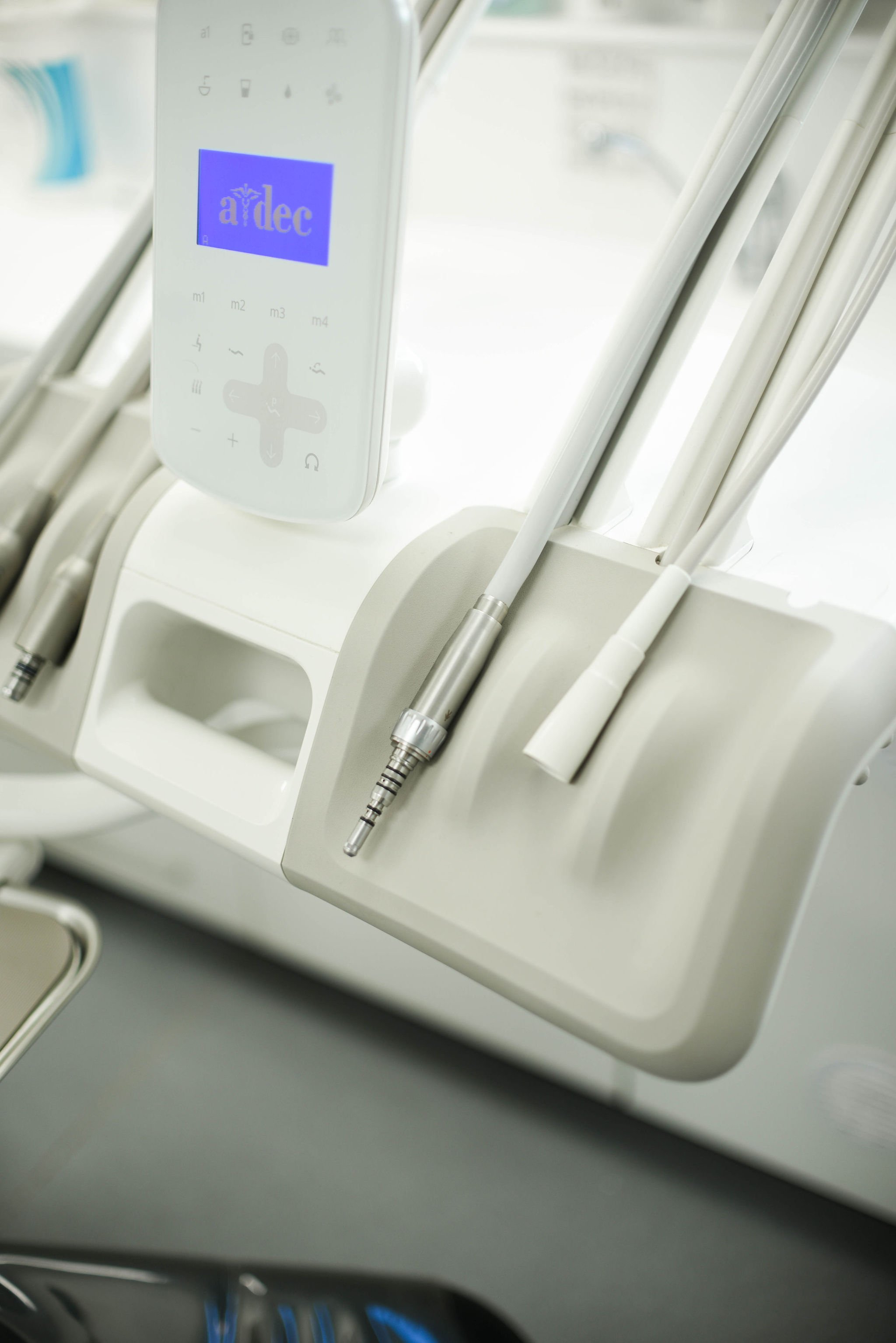 Dental tools and a digital device on a white tray, with the screen displaying the logo 'ardec'.