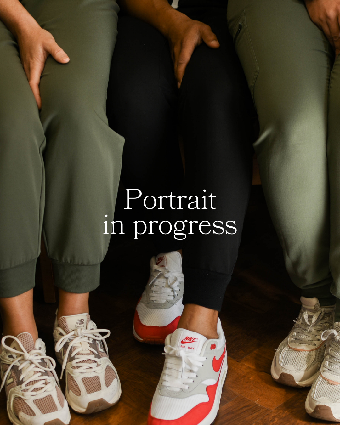 Close-up of three people sitting with their legs and feet visible, wearing athletic shoes and pants, with text overlay 'Portrait in progress' in the center.
