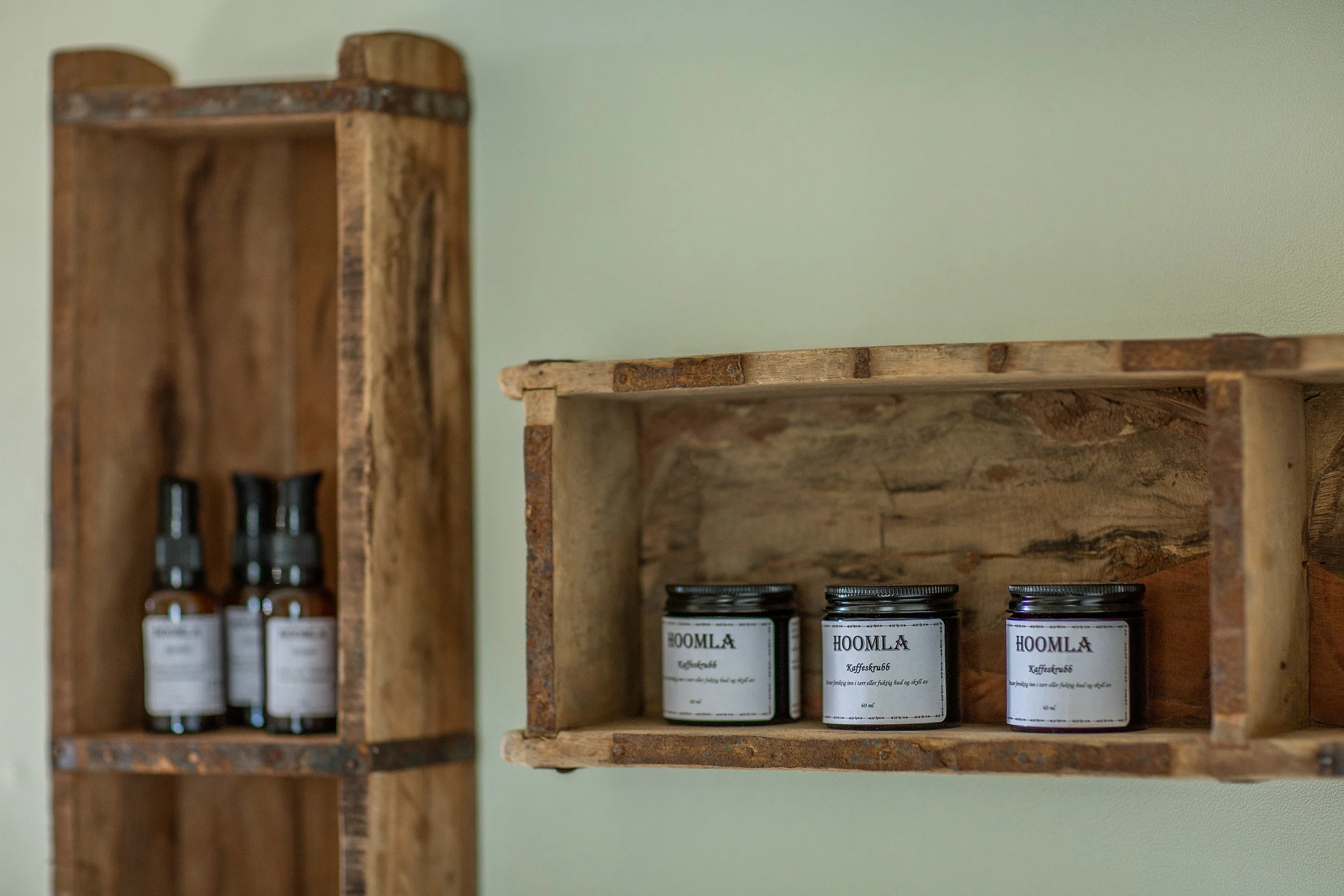 Flasker og glass i rustikke trehyller.