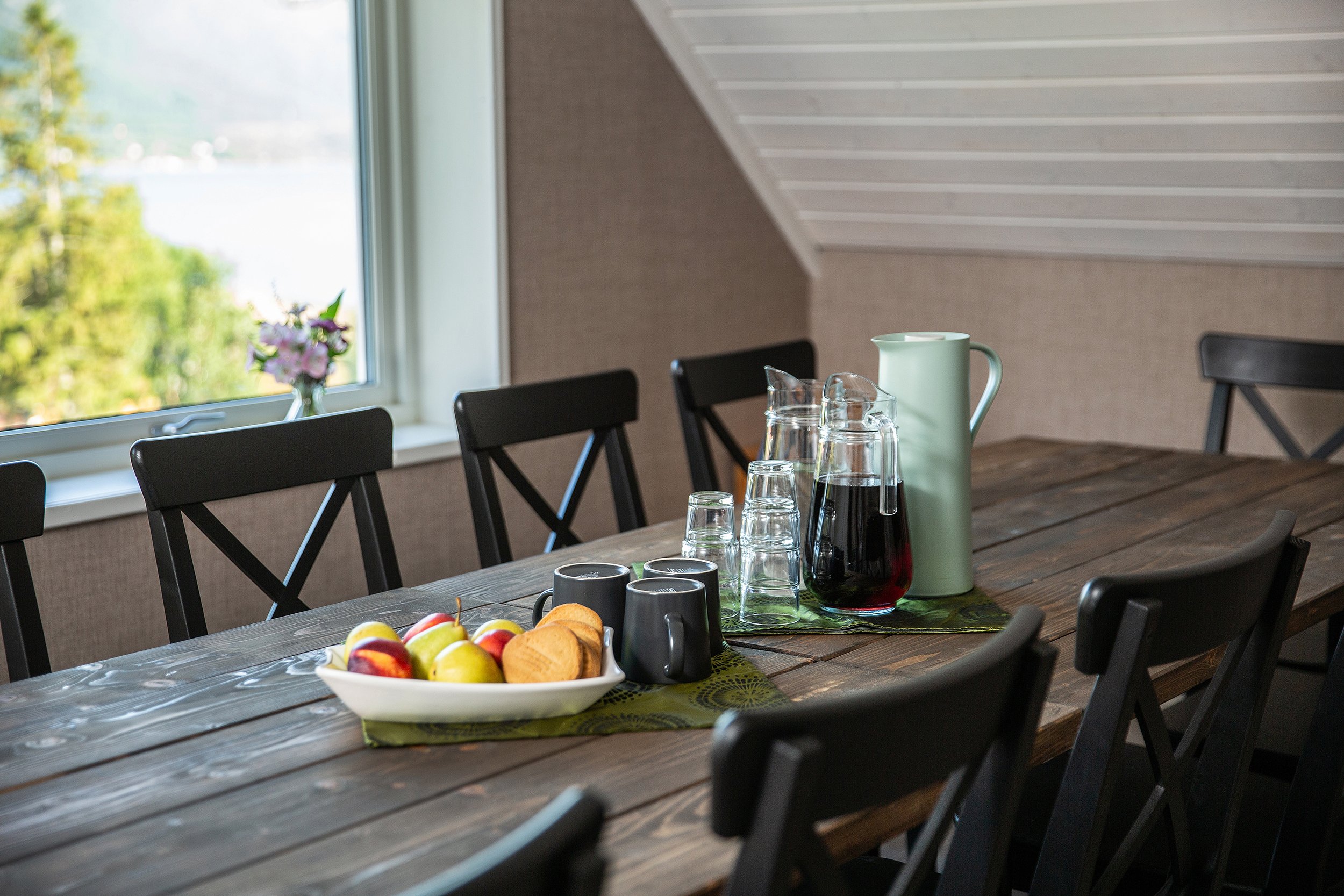 Nærbilde av bord med fruktfat, saft, kaffekanne, kopper og glass.