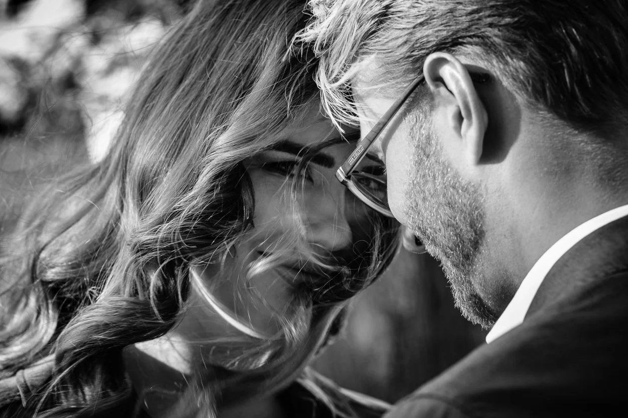Black-and-white close-up of a couple leaning towards one another.