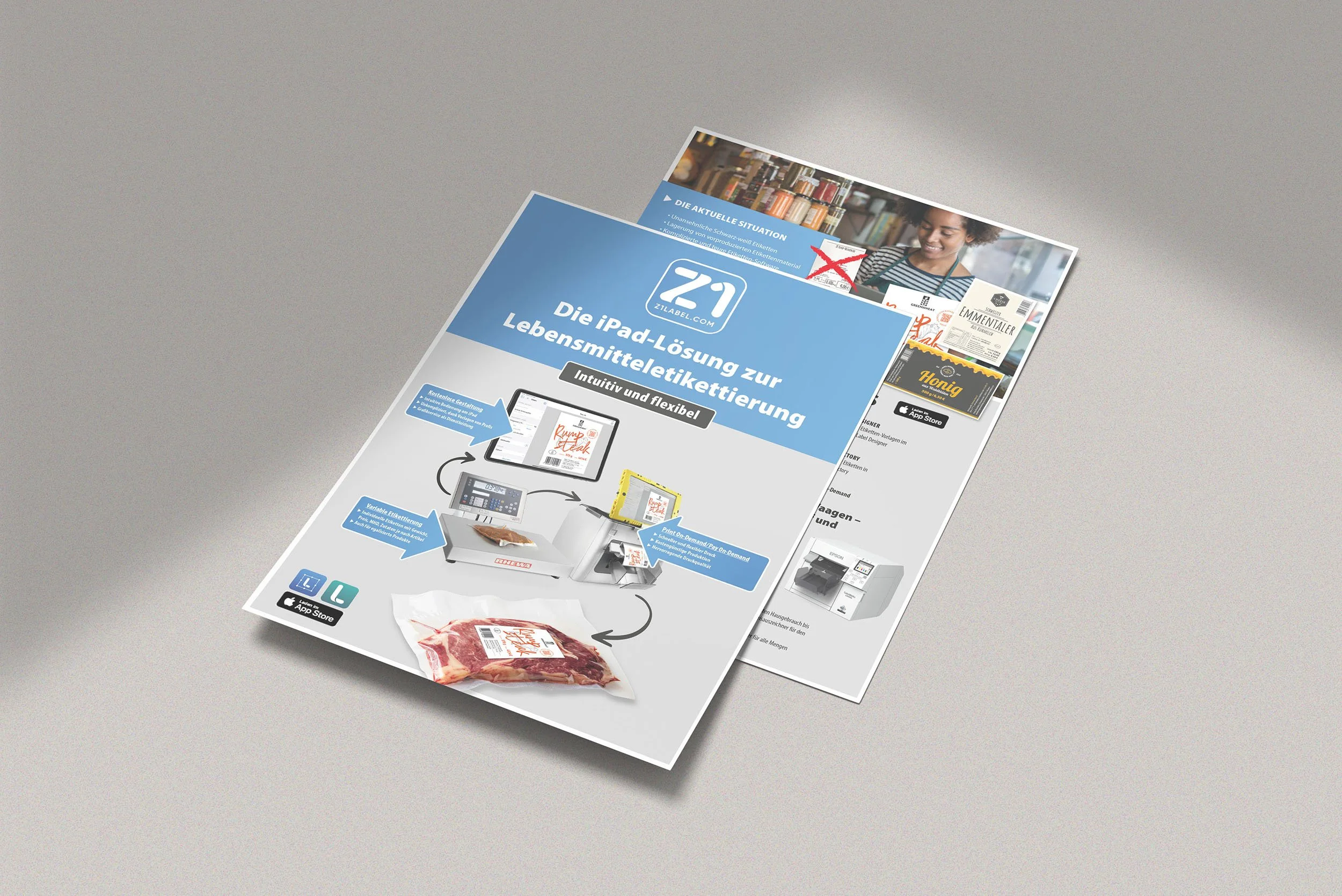 Zwei übereinander liegende Werbeflyer auf einem Tisch. Der obere Flyer bewirbt eine iPad-Lösung zur Lebensmittelkennzeichnung. Es zeigt ein iPad, Etikettendrucker, und Verpackungen mit Etiketten. Der Text besagt ‚Die iPad-Lösung zur Lebensmitteletike