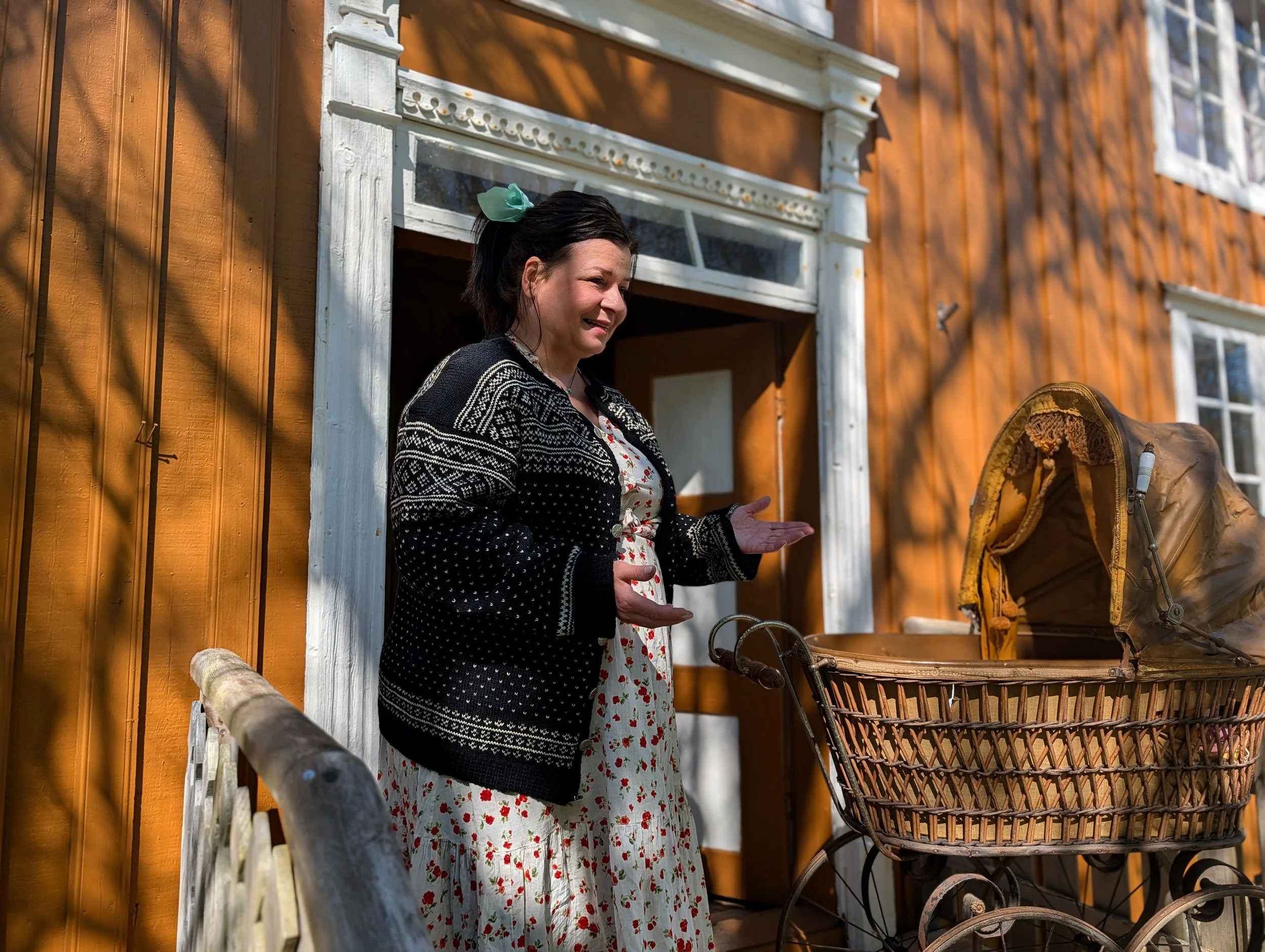 Weibliche Reiseleiterin vor der Tür des alten ockerfarbenen Hauses.