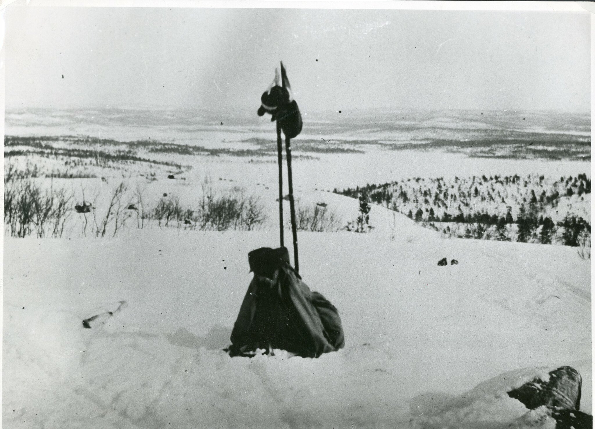 En ryggsekk og et par skistaver i et snødekt landskap