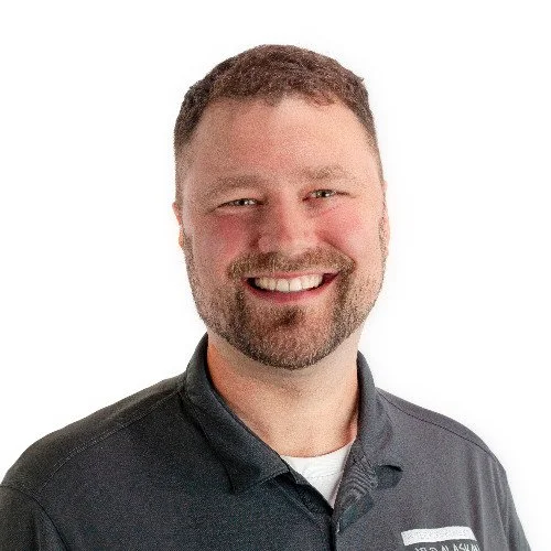 Smiling man in a gray polo shirt on a white background