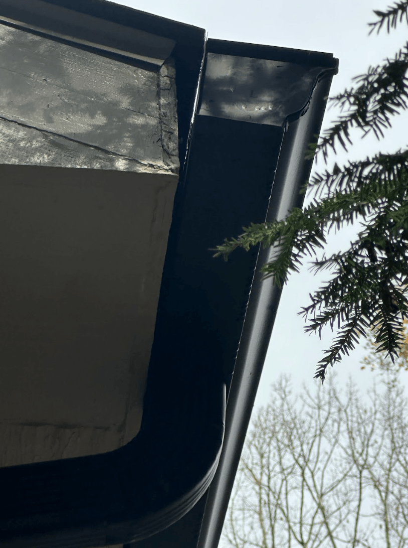 Close-up of a detached gutter pulling away from a roof edge, showing separation from the house and potential water damage risk in Chattanooga, Tennessee