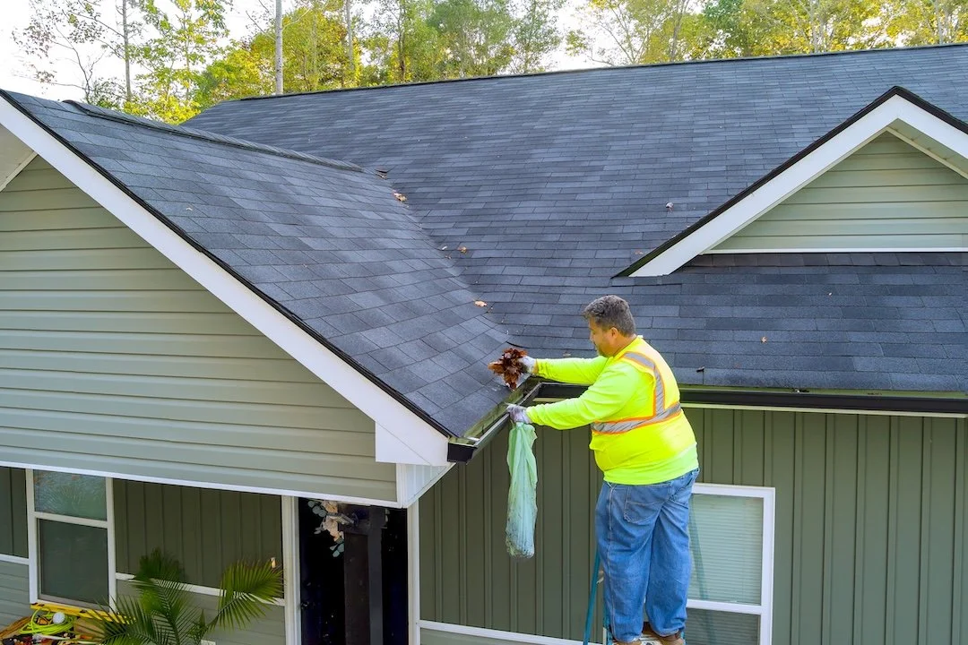 Our Chattanooga gutter cleaning service in action. A technician removes tree debris and leaves to prevent clogs and protect your home from water damage.