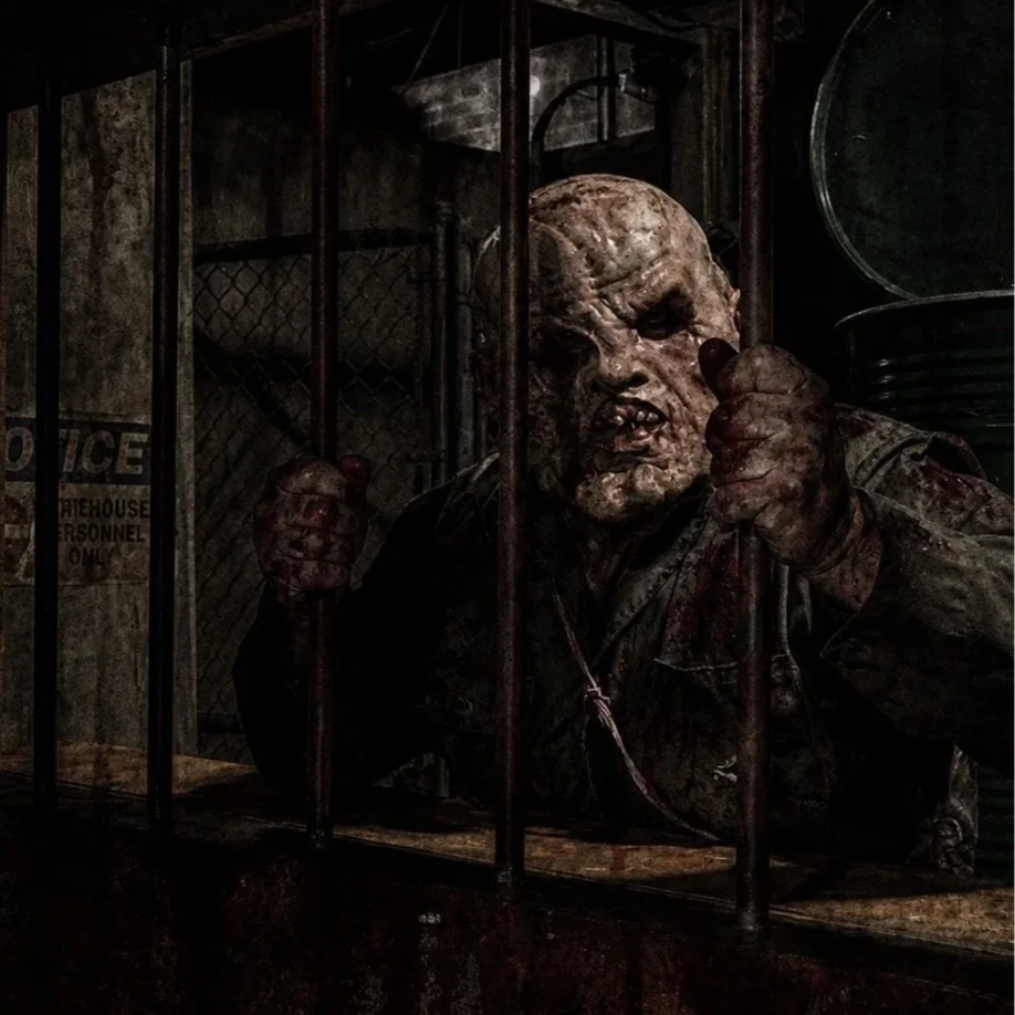 Haunt Actor in costume posing through jail windows in a haunted attraction