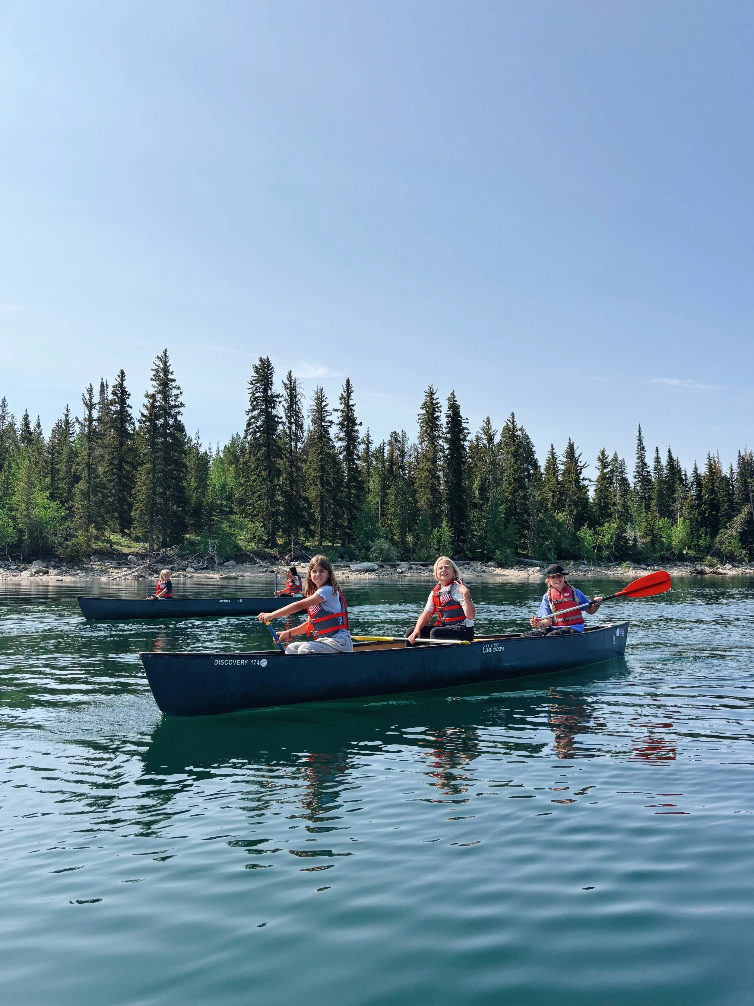Three young girls paddling a canoe on New Fork Lake.