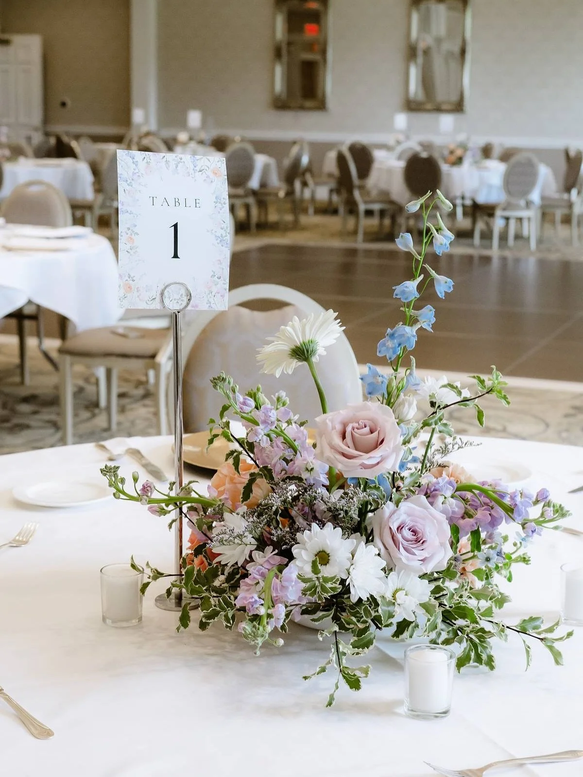 The Hickory Hills ballroom was in full bloom with pastel garden-style florals. Dreamy floral centerpieces paired with sweet clusters of bud vases throughout the room, ranging in pastels from blues to peaches to purples. To make their wedding celebrat