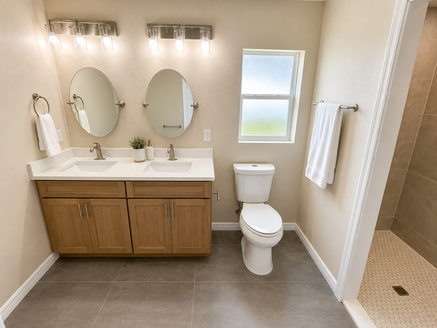 Primary bathroom with dual sinks and walk in tiled shower