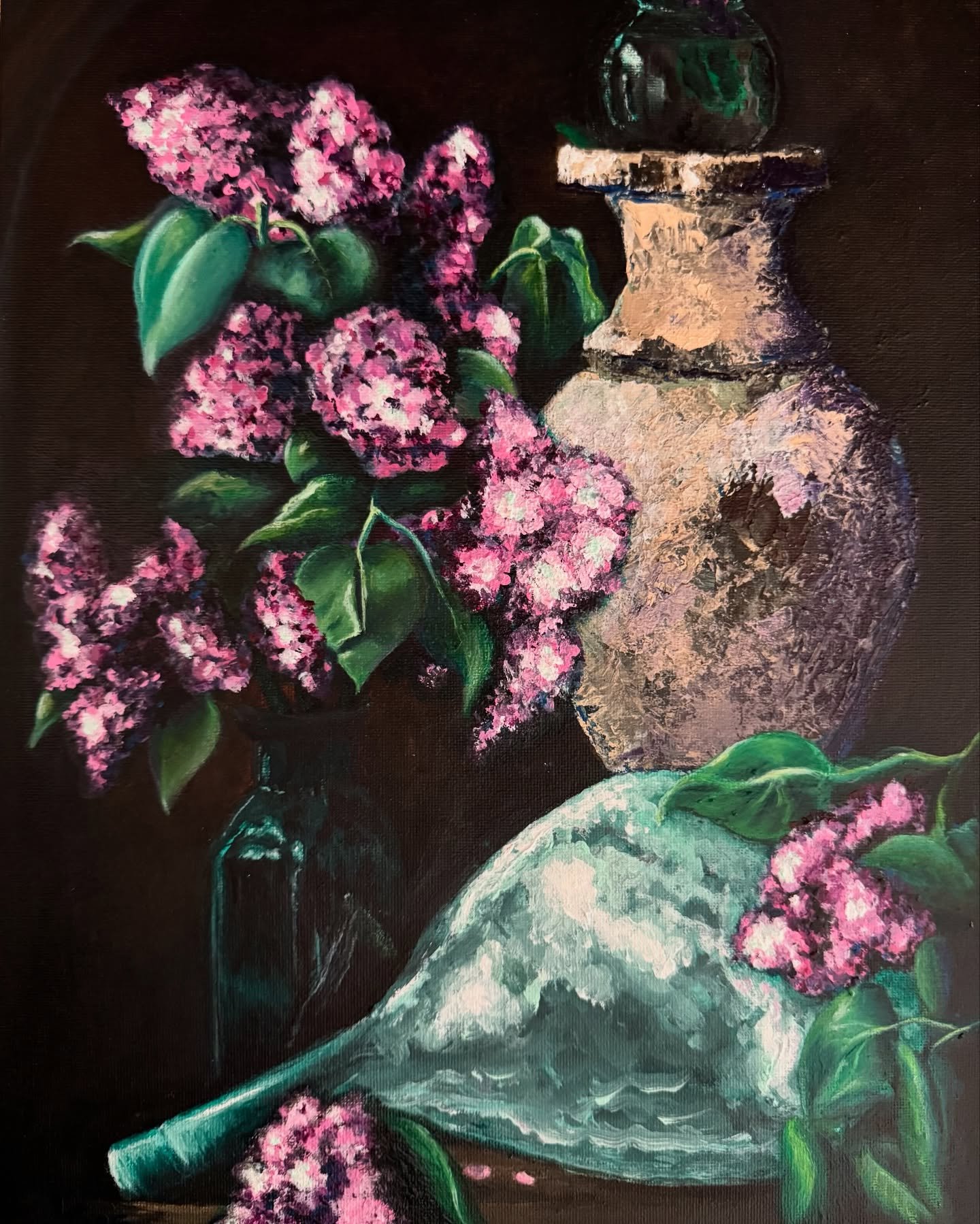 The Quiet Persistence of Femme
Softness isn’t silence. It’s strategy.
Like lilacs breaking through stone,
this piece speaks of resilience not by shouting—but by enduring.
A weathered urn, a glass vessel, and blooms that refuse to wi