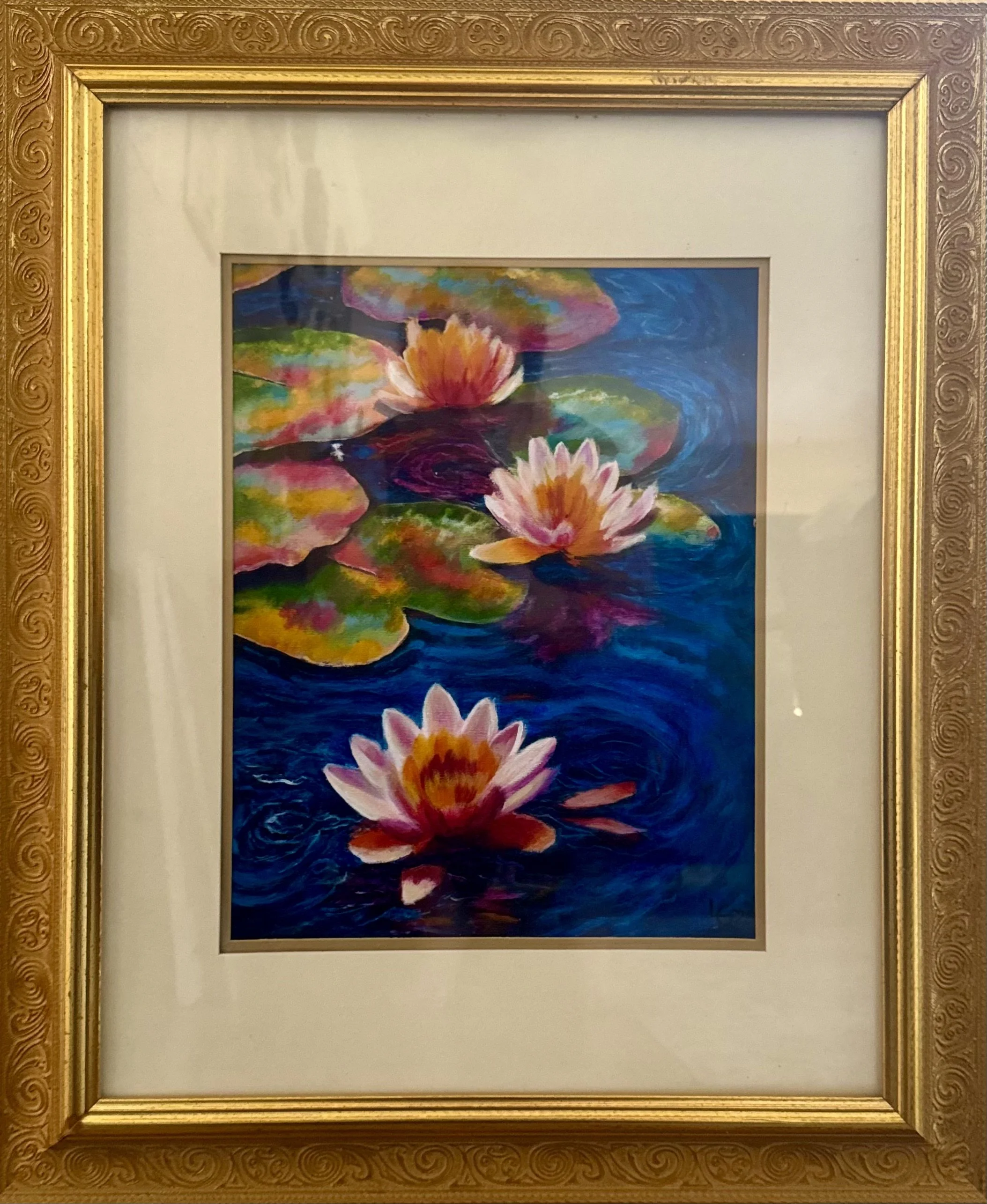 A colorful watercolor painting of water lilies floating on water, framed with a decorative gold and wood frame.