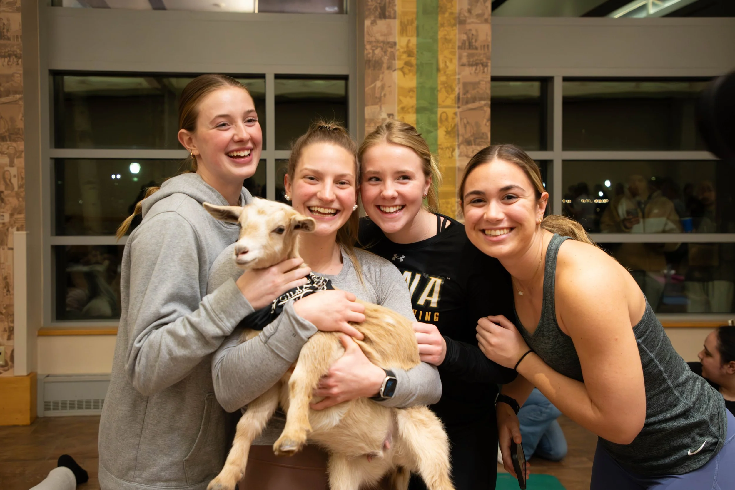 what are the things to consider before trying goat yoga photo of girls holding a goat