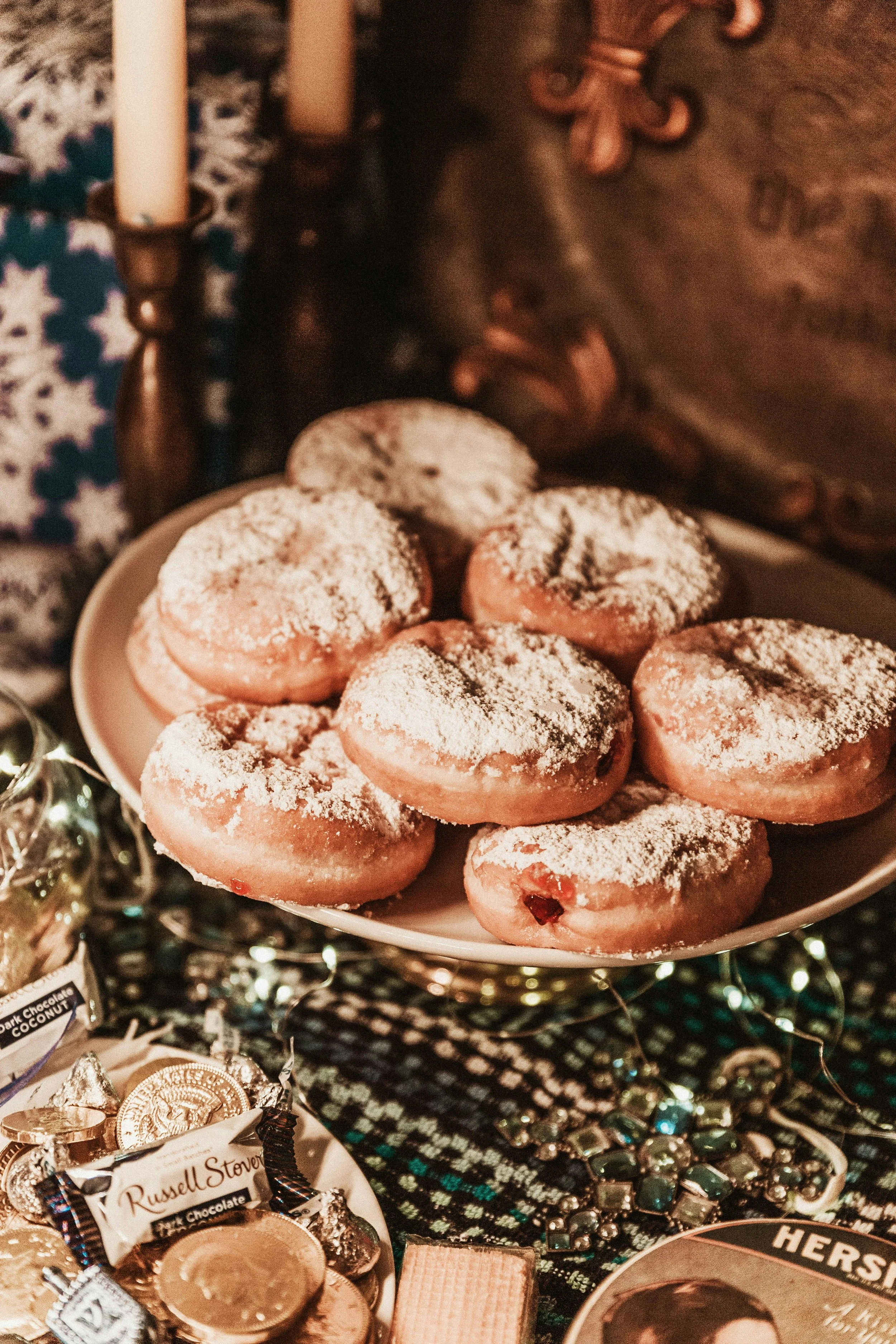 Sufganiyah donuts, snacks, and lights on a table. Sustainable holiday decor and food that minimizes waste and optimizes home organization. West Olympia, Washington