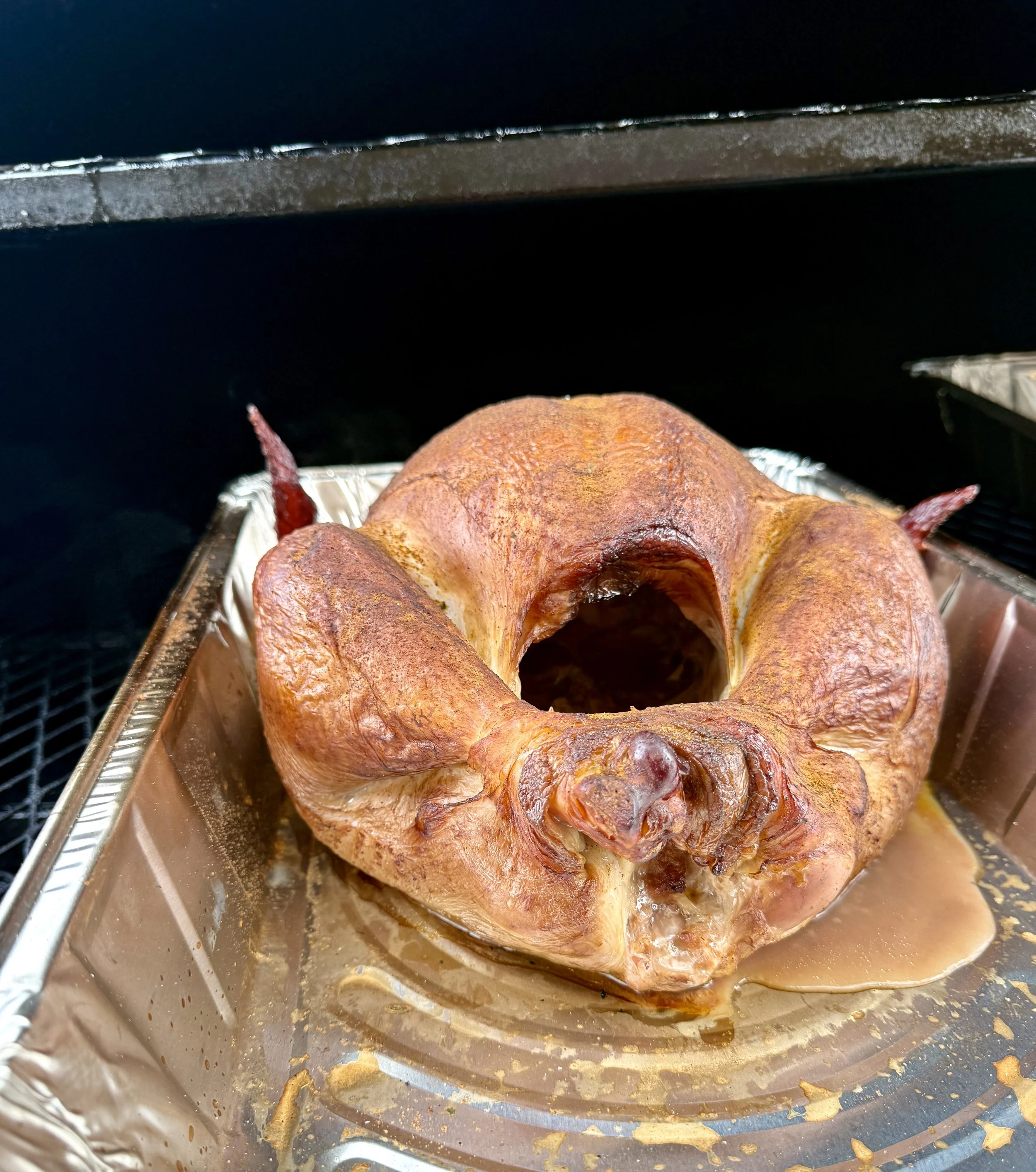 Whole turkey being smoked on a reverse flow smoker by Crooked Creek Ranch.
