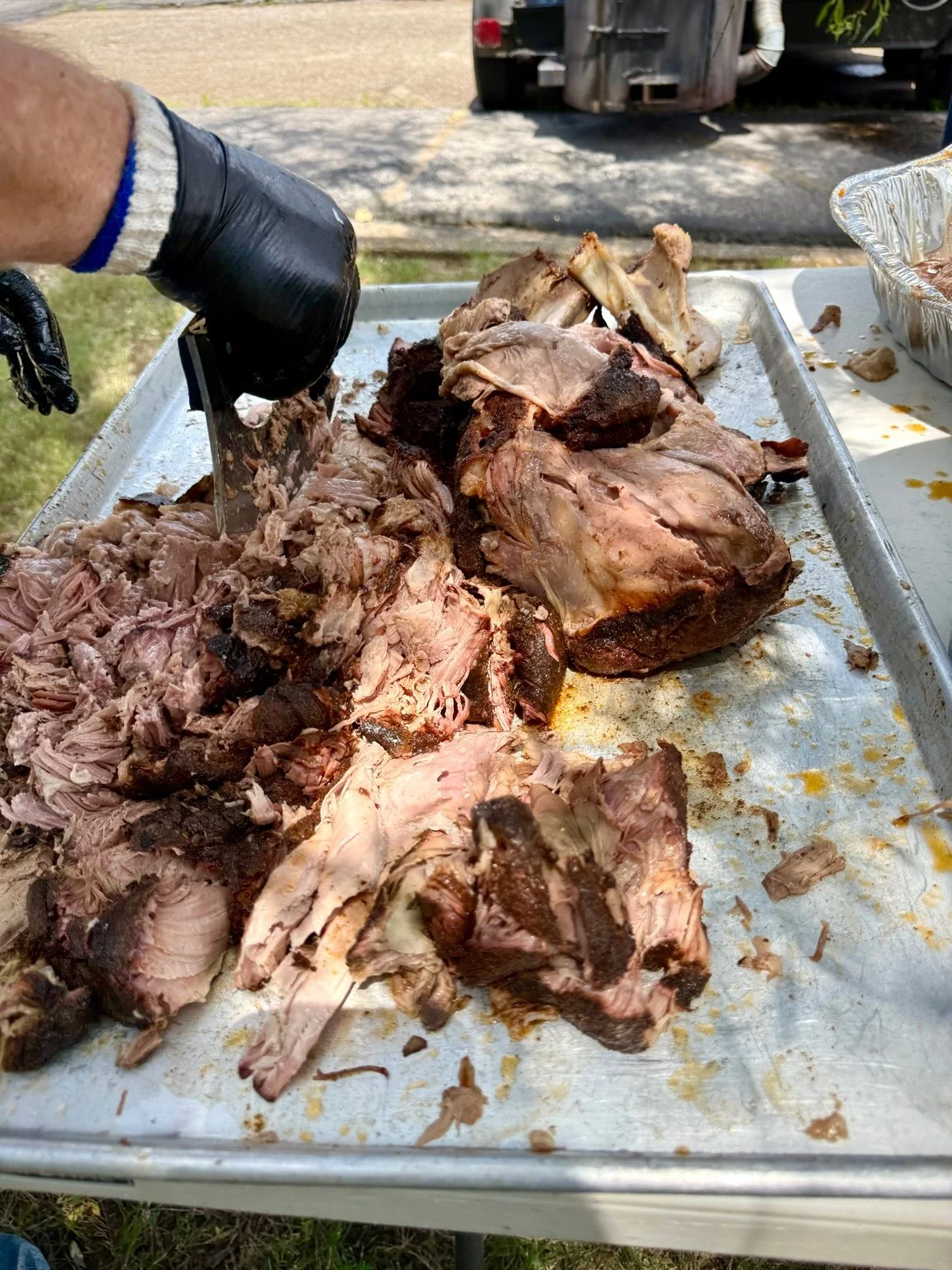 Chopping pulled pork Boston butt to make a giant pan of pulled pork to feed a crowd