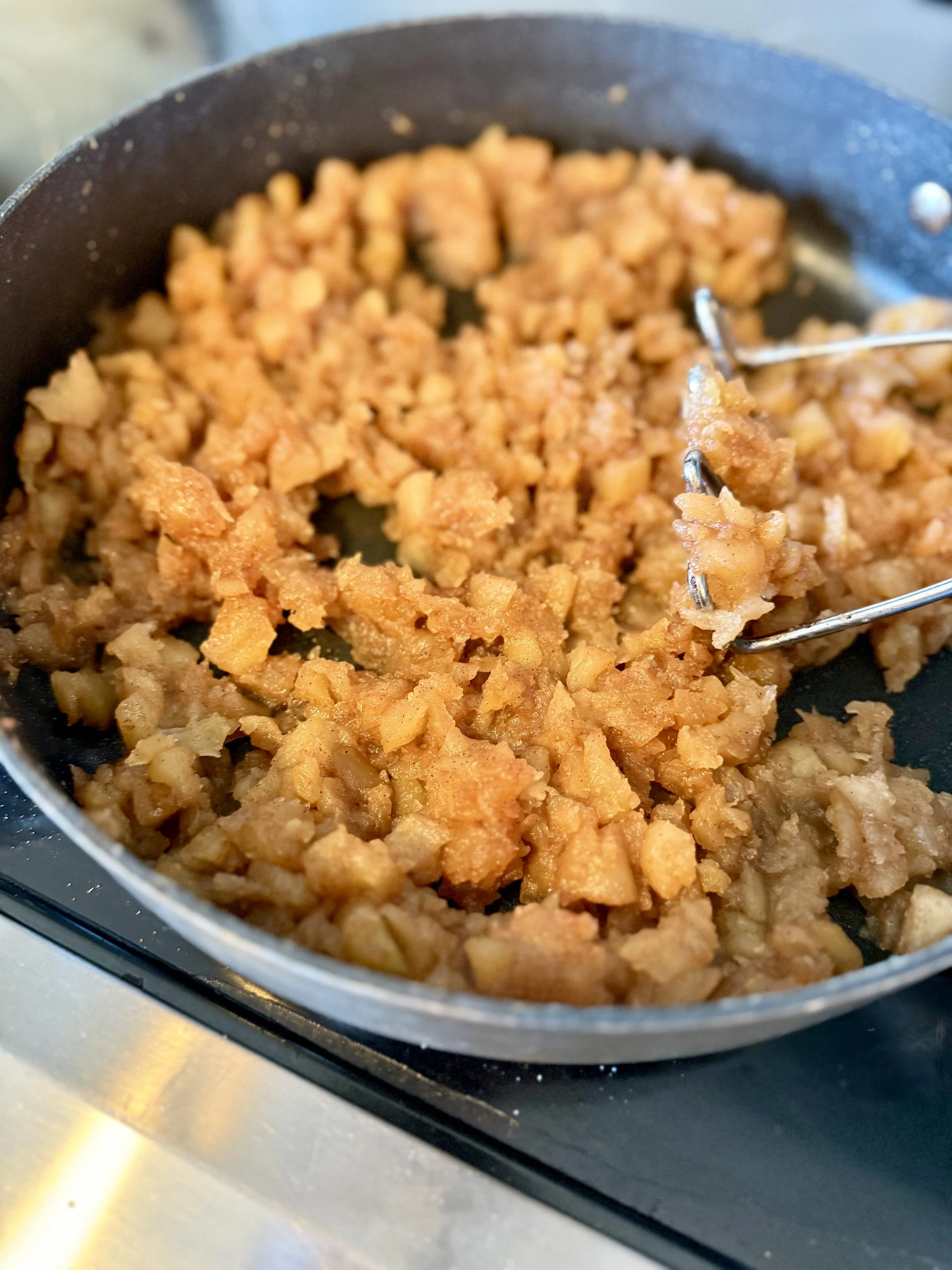 A cast iron skillet simmering the perfect apple pie filling for Southern fried apple pies.